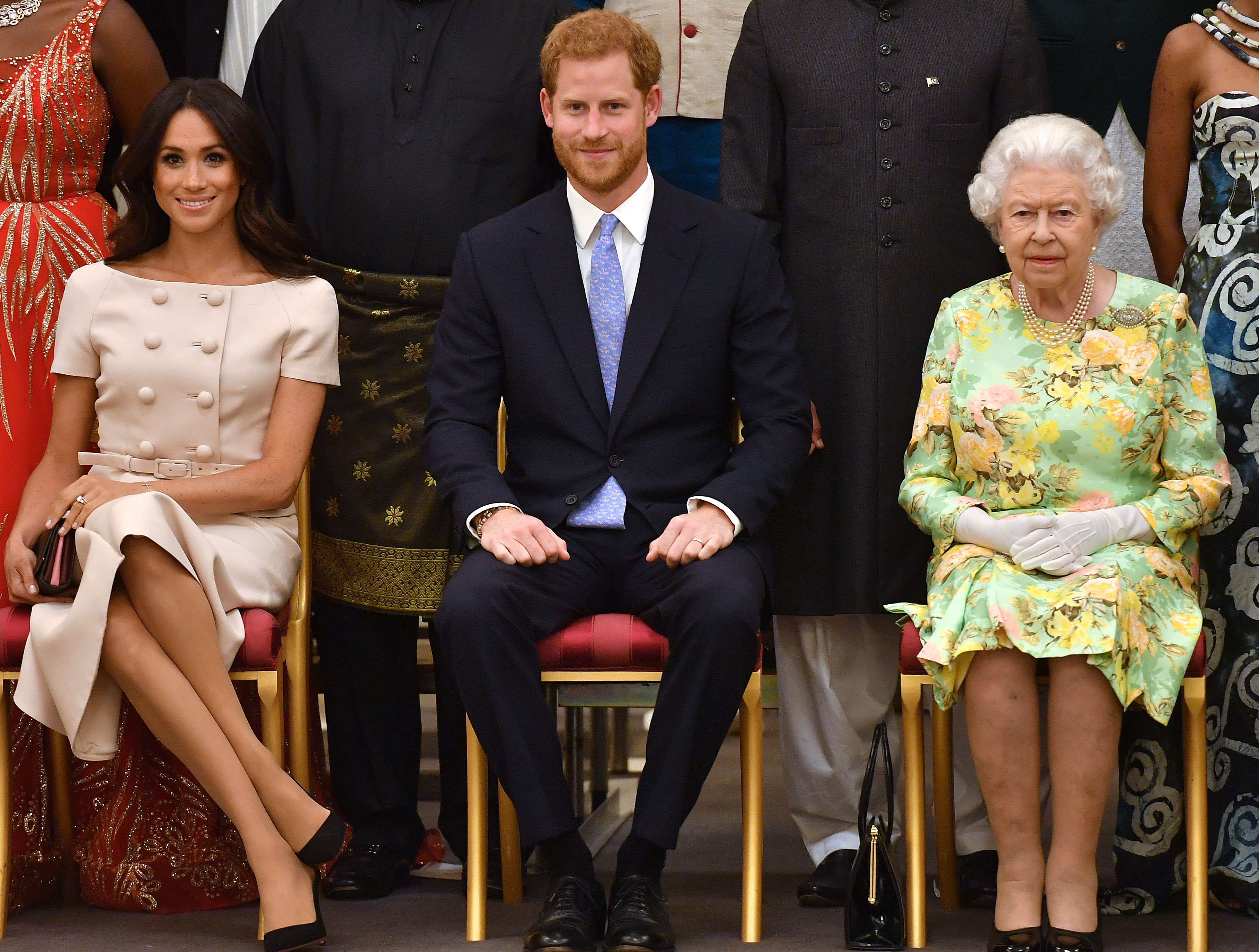 Meghan Markle, Prince Harry, and Queen Elizabeth II sitting next to each other at the Queen's Young Leaders Awards Ceremony