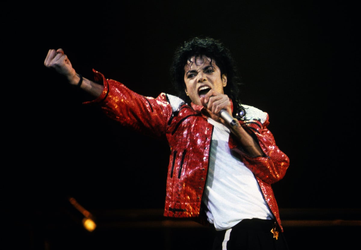 Michael Jackson wears a red jacket and performs in concert