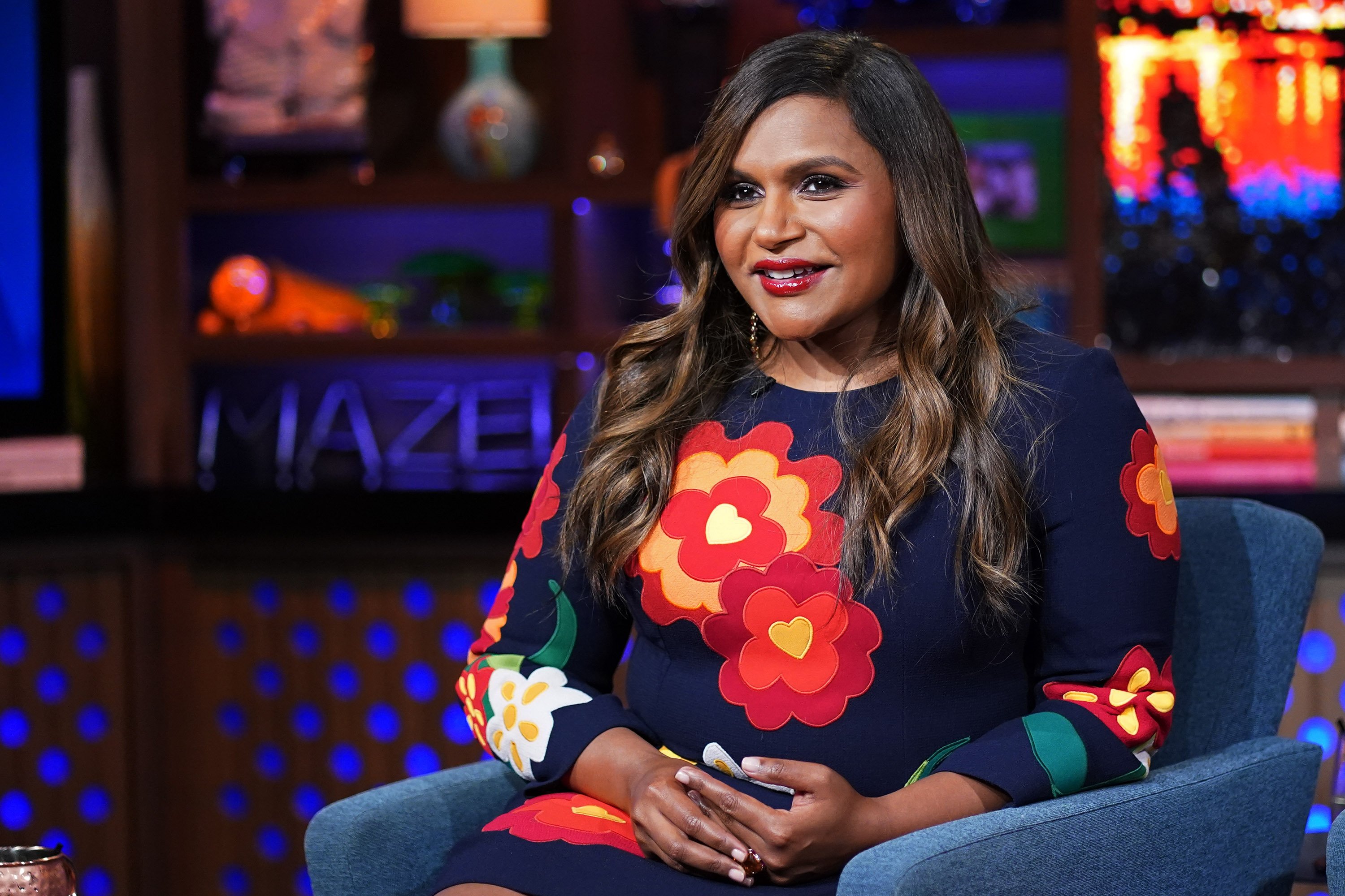 Mindy Kaling sits in a chair while on 'Watch What Happens Live with Andy Cohen'