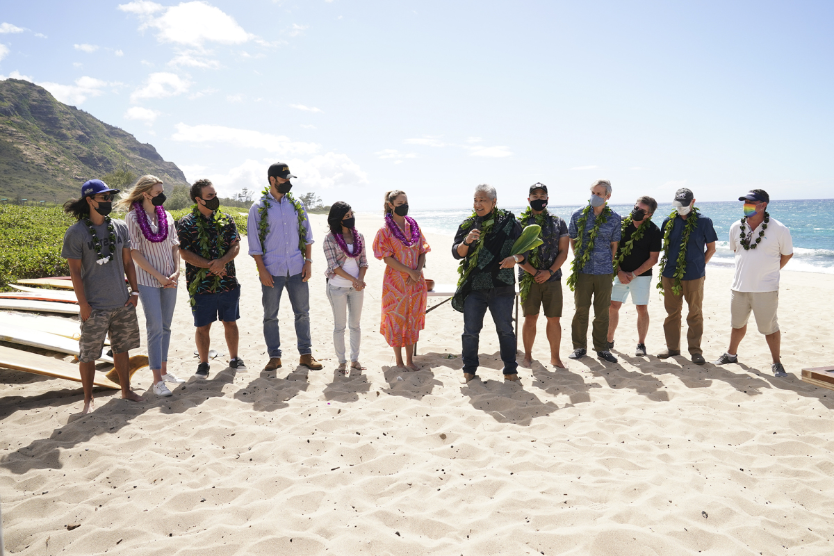 The NCIS: Hawaii cast stands on the beach.