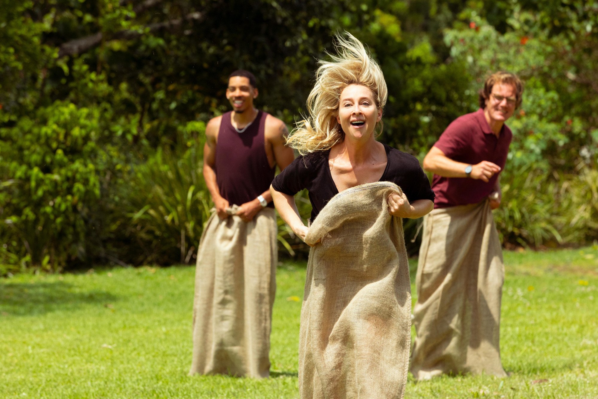 'Nine Perfect Strangers' Episode 3: Ben (Melvin Gregg), Heather (Asher Keddie), and Napoleon (Michael Shannon) racing in potato sacks.