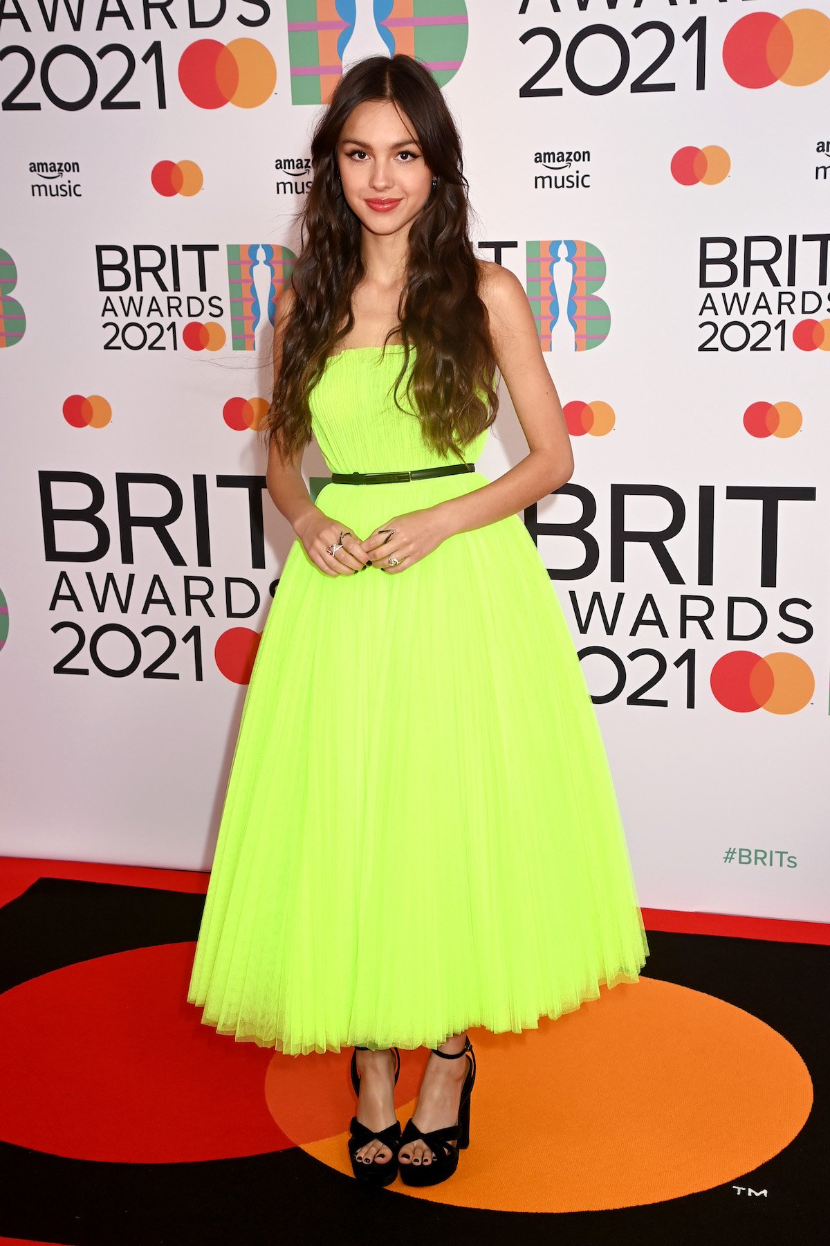 Olivia Rodrigo poses in a lime green dress.