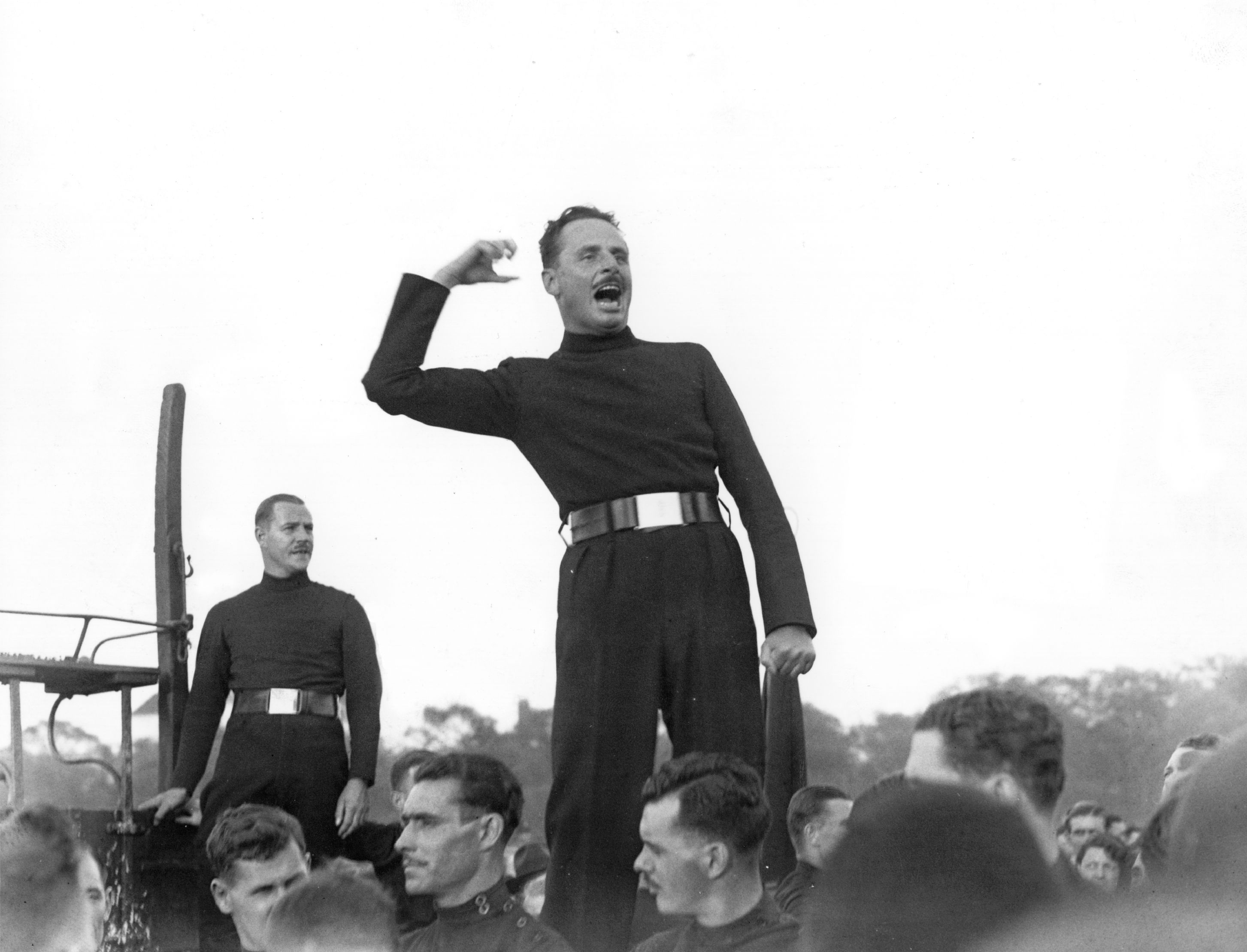 Oswald Mosley wearing a distinctive brown uniform and screaming.