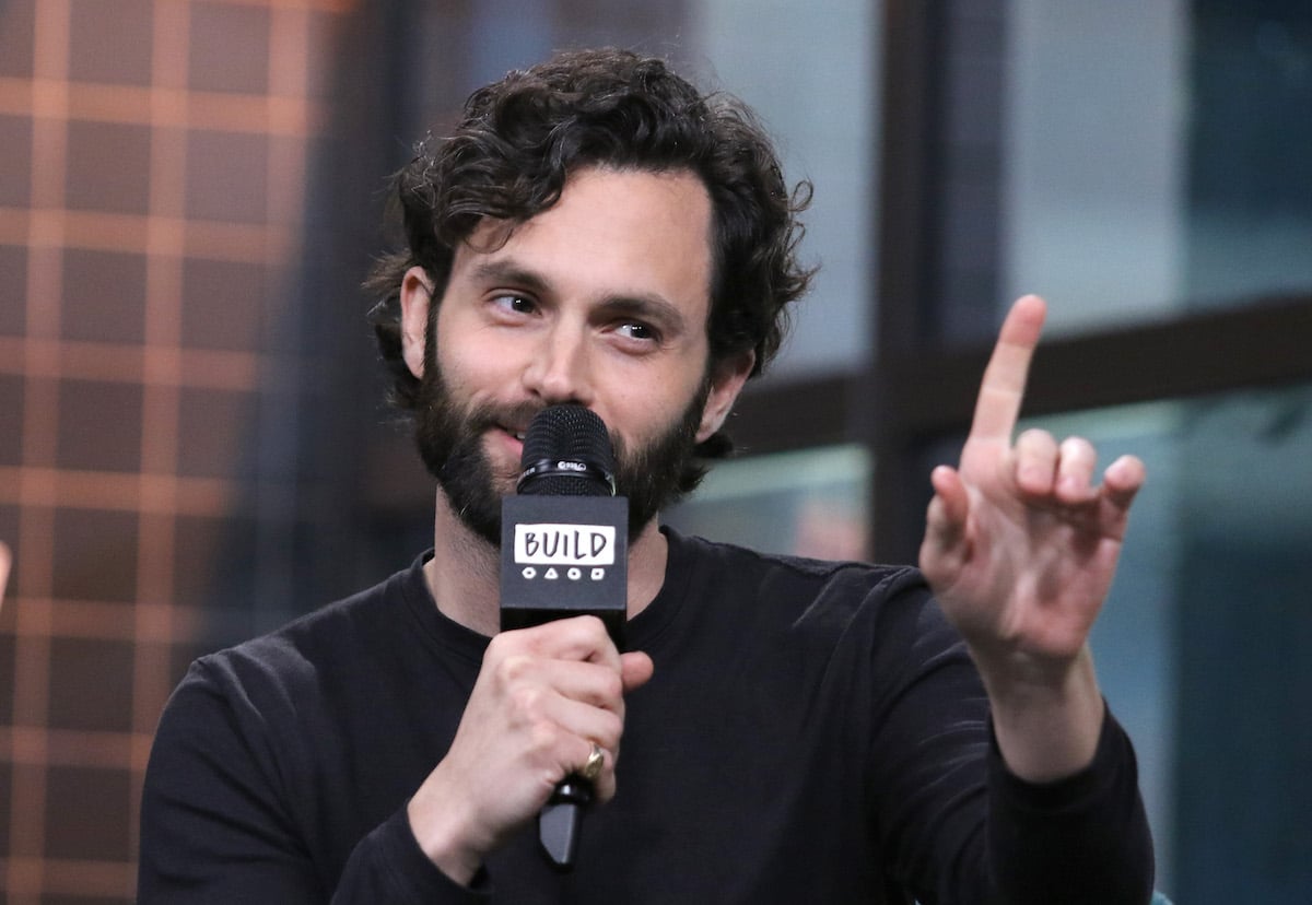 Penn Badgley holding a microphone.