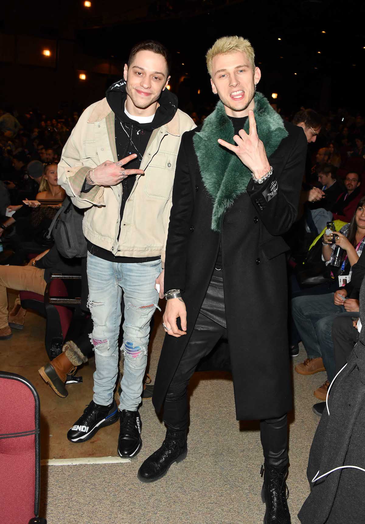 Pete Davidson and Machine Gun Kelly flash peace and hang loose signs at the camera.