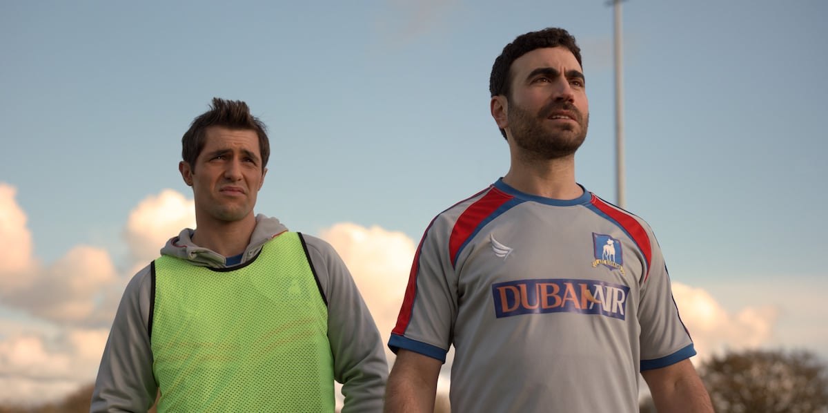 Phil Dunster as Jamie Tartt wearing a bright yellow jersey and Brett Goldstein as Roy Kent in a Richmond jersey in 'Ted Lasso'