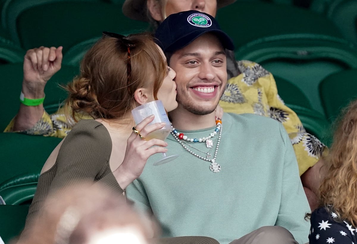 Phoebe Dynevor kisses Pete Davidson while they watch a match at Wimbledon.