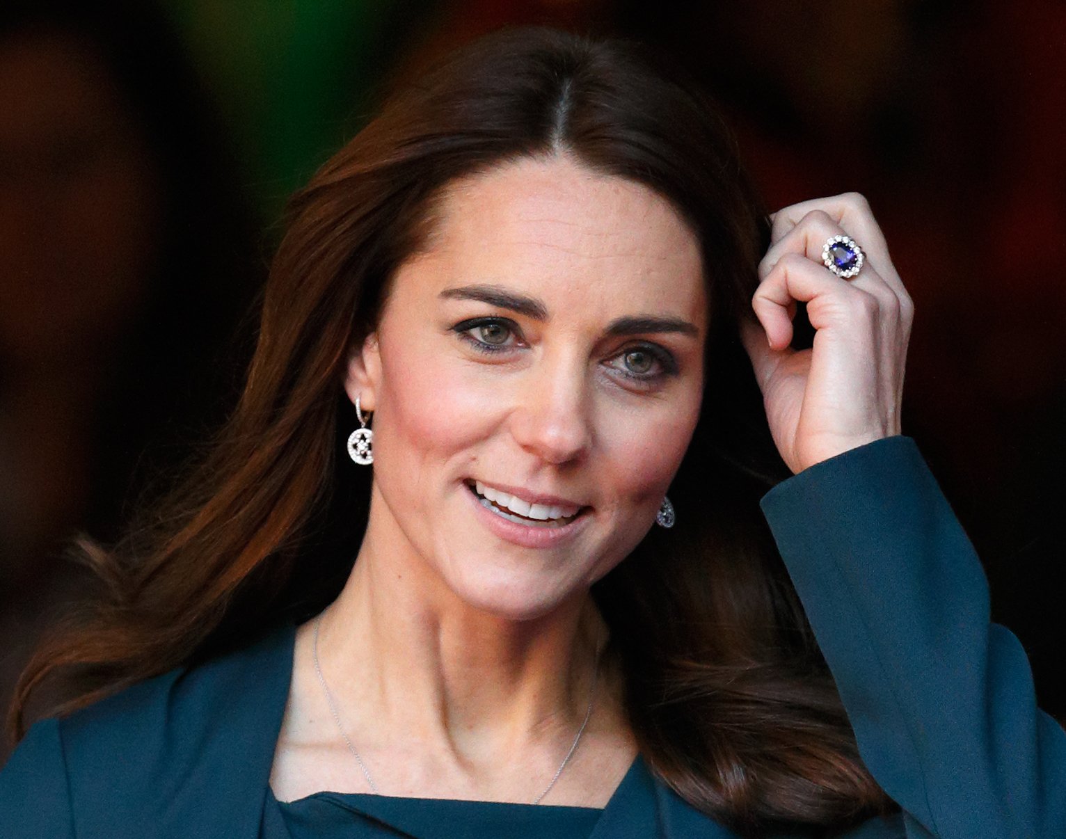 Photograph of Kate Middleton from the shoulders up poushing her hair out of her face