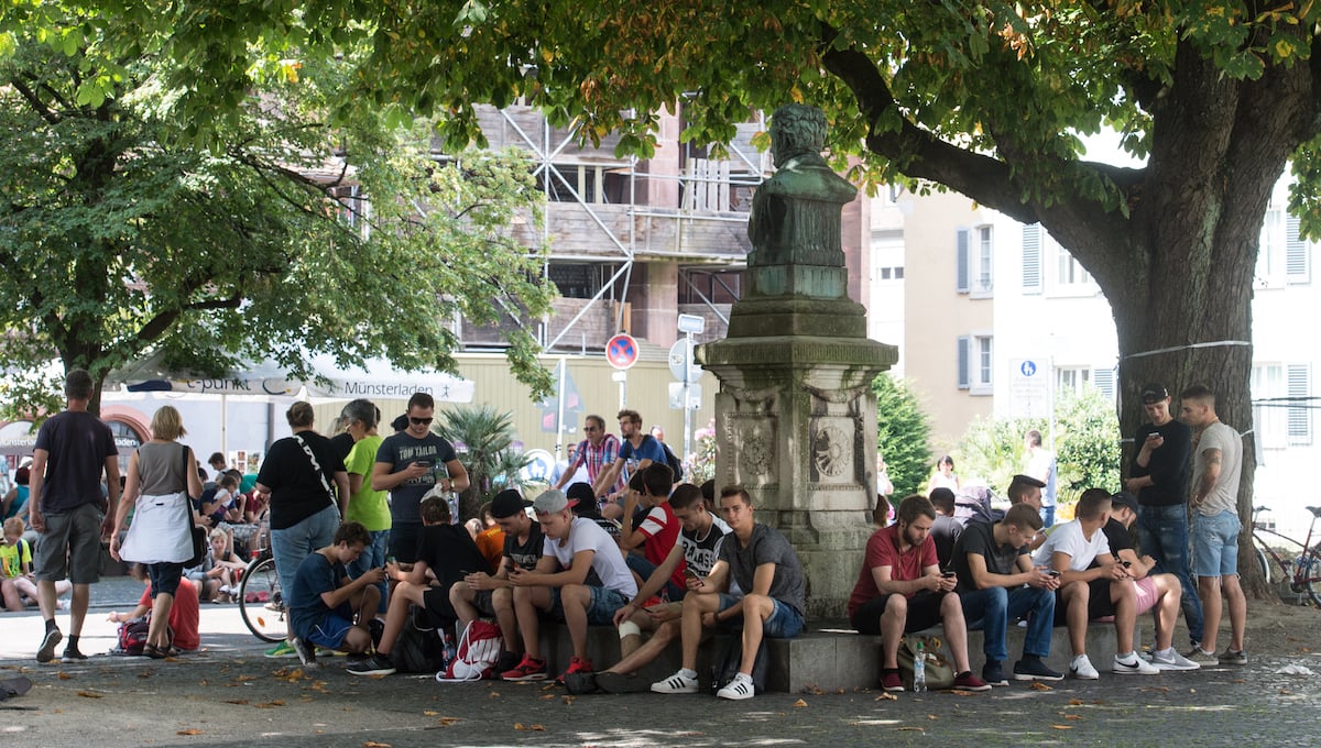 A large crowd of Pokemon Go players gathers at a popular stop.