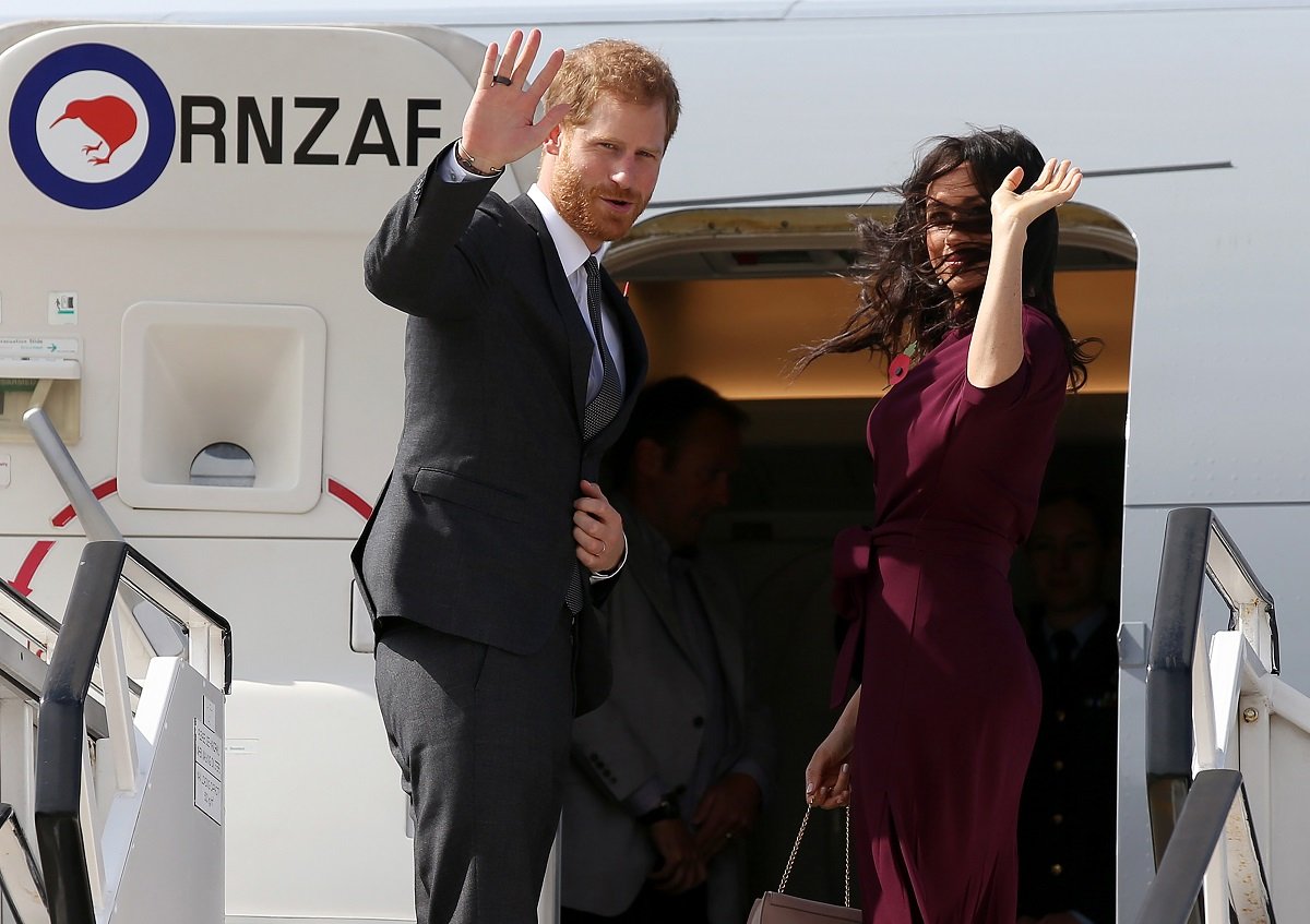 Prince Harry and his wife Meghan wave as they board aeroplane in Sydney