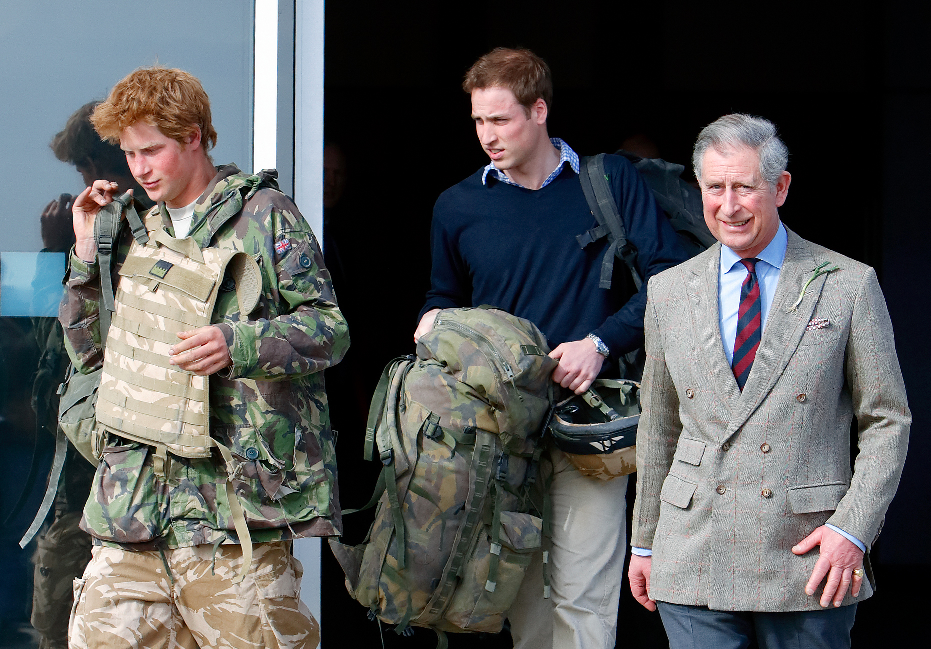 Prince Harry, carrying his rucksack as he returns from Afghanistan accompanied by Prince William and Prince Charles