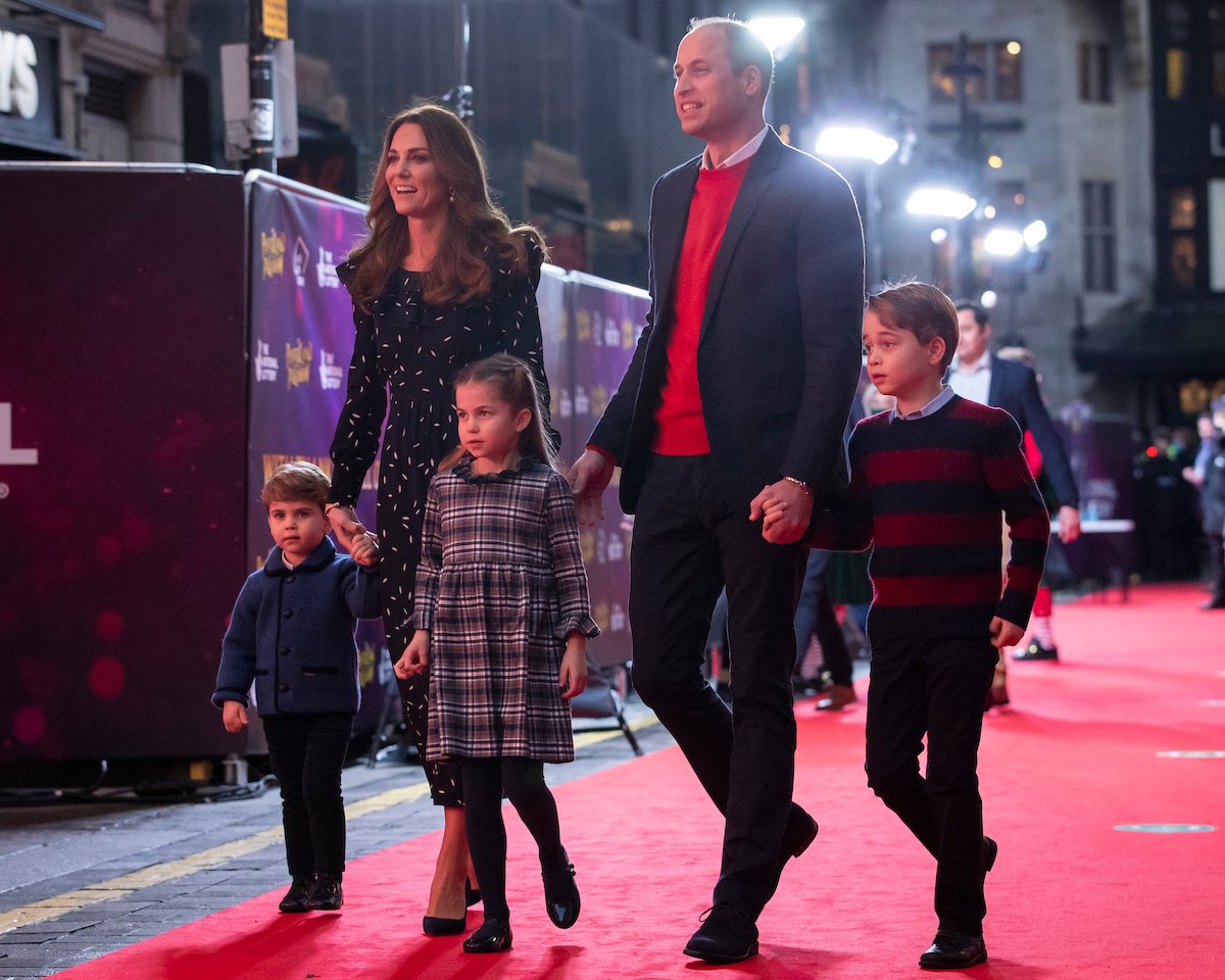 Prince William and Kate Middleton hold hands with Prince George, Princess Charlotte, and Prince Louis on the red carpet in 2020