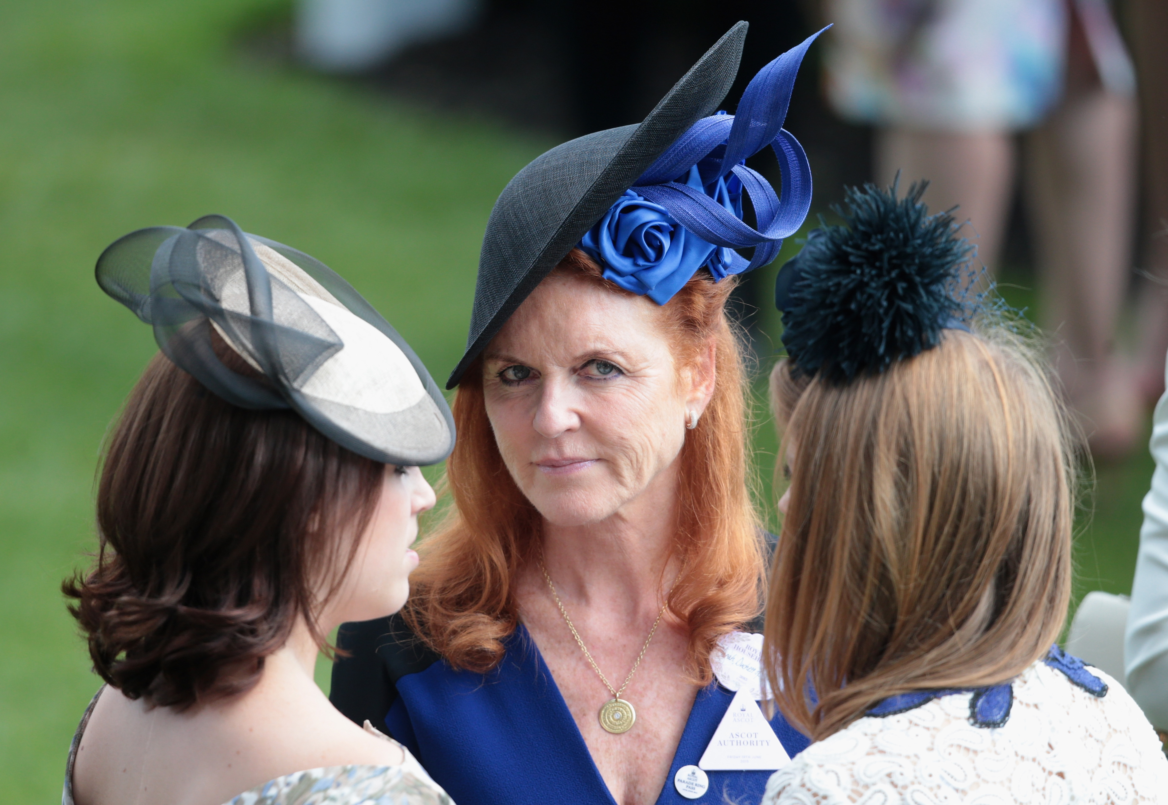 Princess Eugenie, Sarah Ferguson, and Princess Beatrice standing together in the parade ring of Royal Ascot