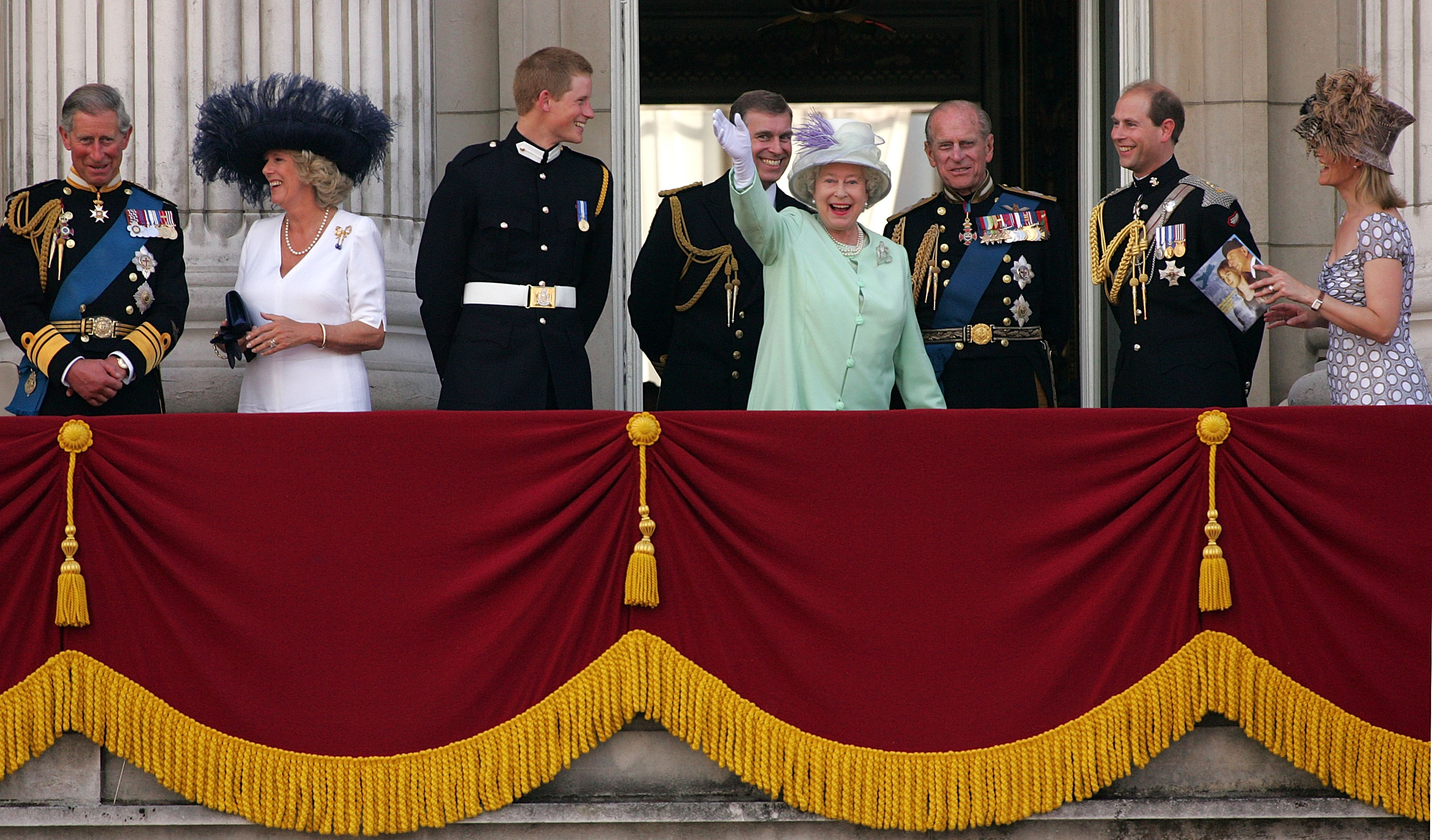 Queen Elizabeth waving as she stands on the balcony of Buckingham Palace with her sons and other royals