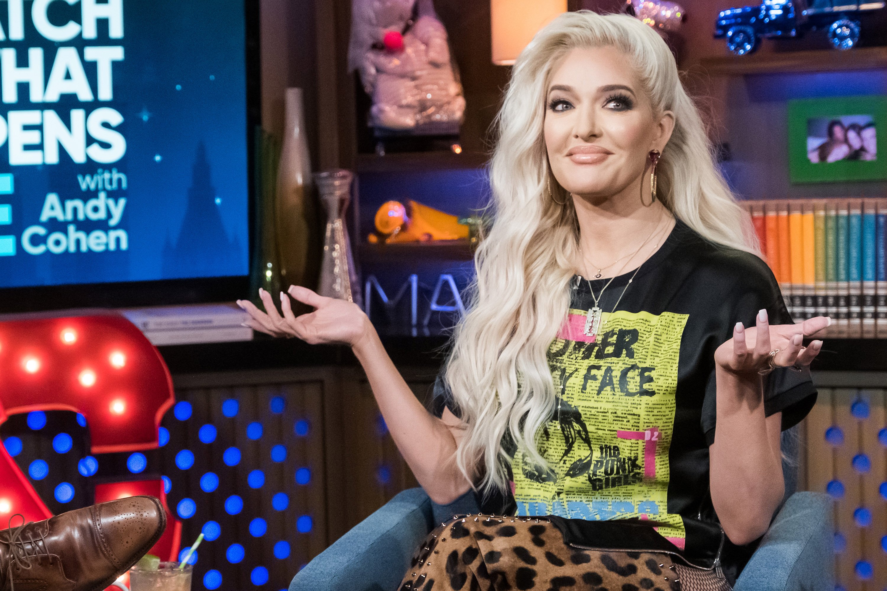 'Real Housewives of Beverly Hills' star Erika Jayne smirking with her hands in the air during an appearance on 'Watch What Happens Live'
