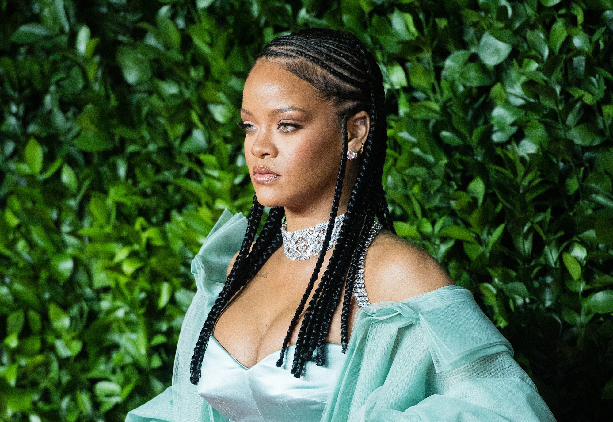 Rihanna in front of a green background