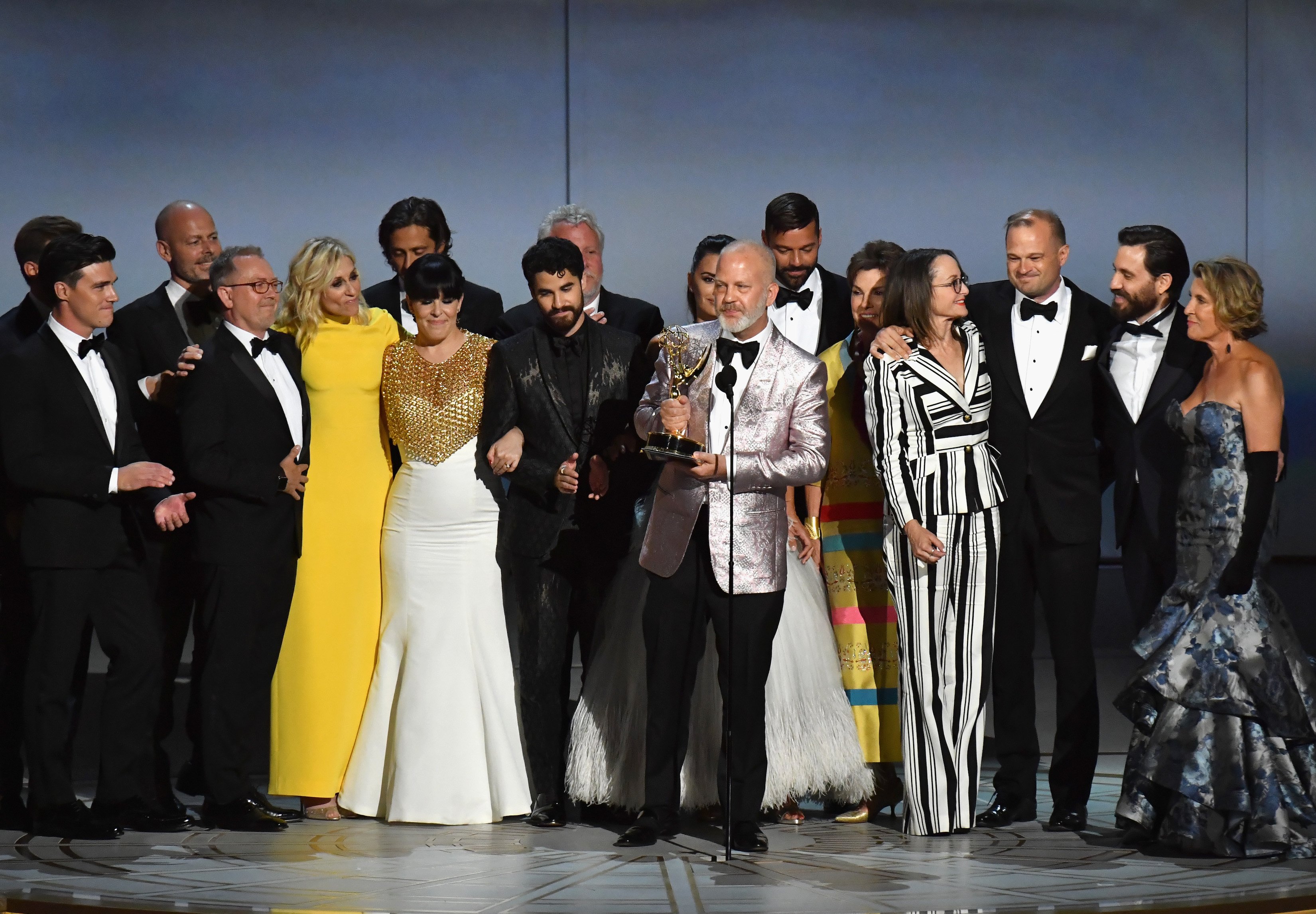 Ryan Murphy and cast and crew talking onstage to receive the Outstanding Limited Series award for The Assassination of Gianni Versace: American Crime Story