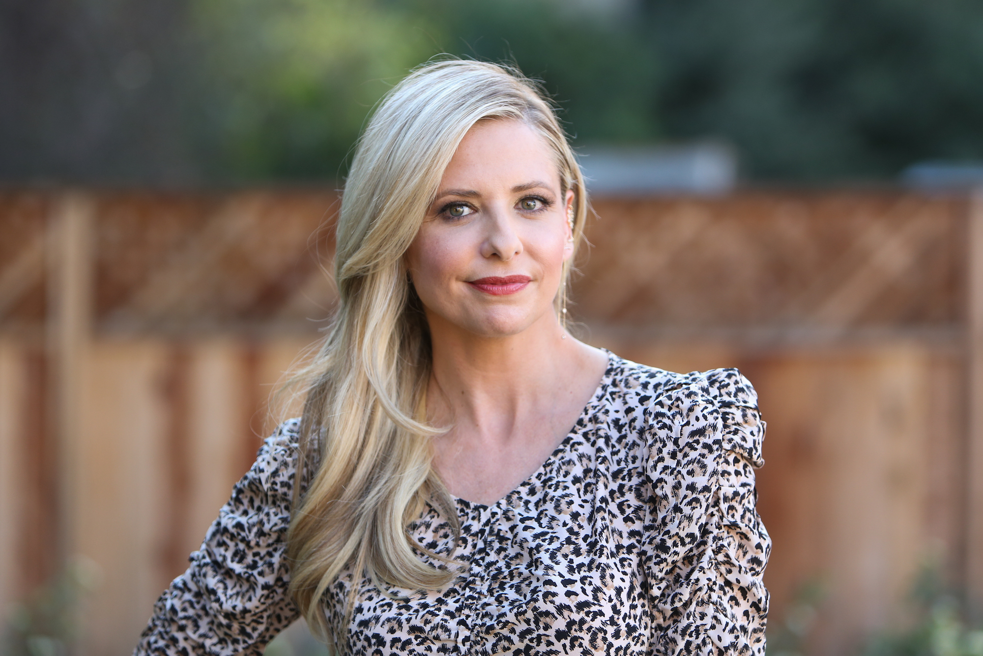 Sarah Michelle Gellar smiling in front of a blurred background