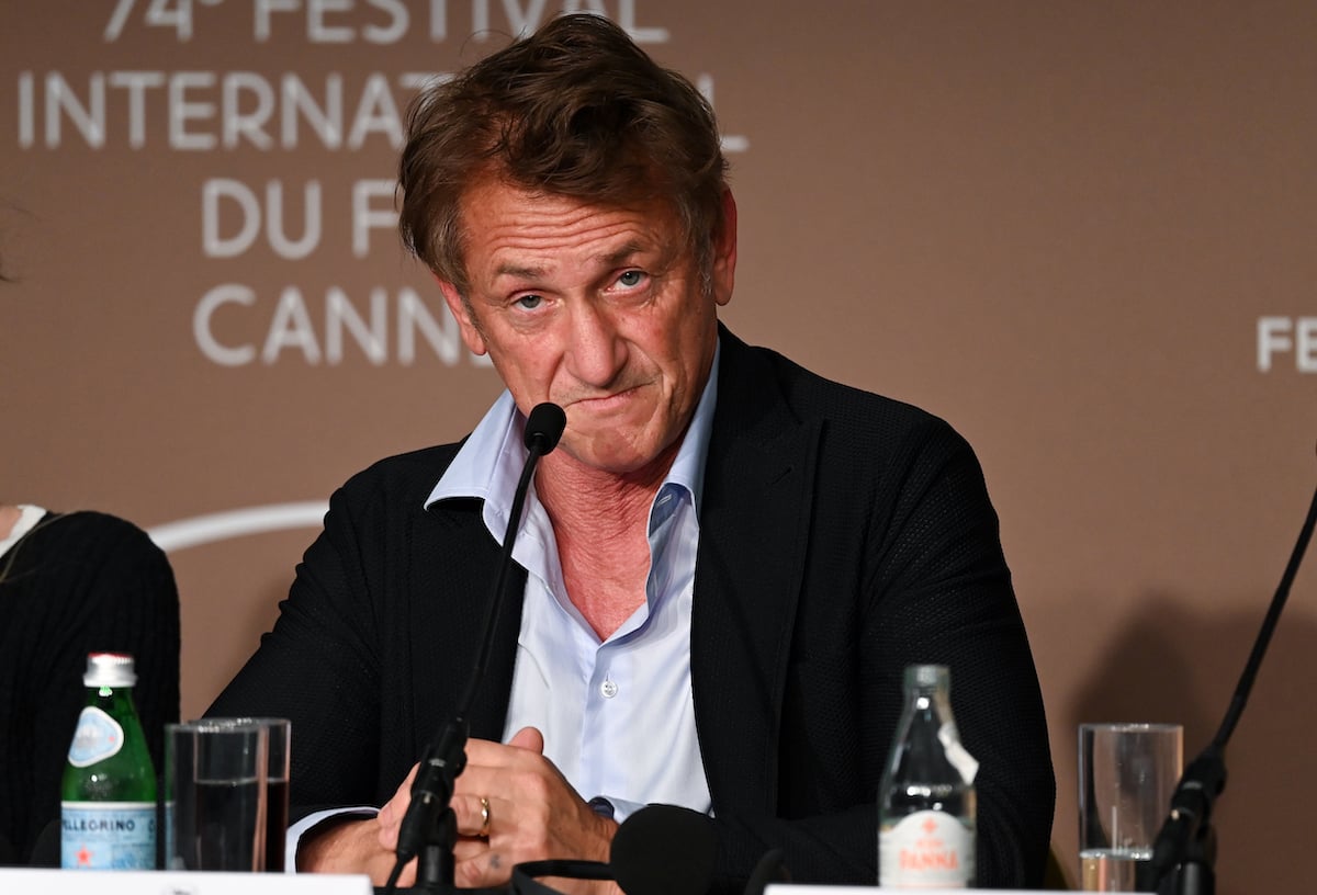 Sean Penn sitting near a microphone.