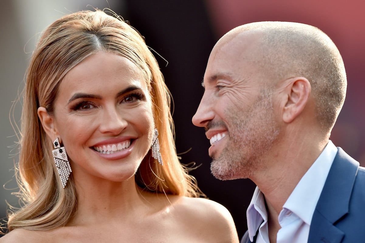 Jason Oppenheim smiles at Chrishell Stause on the red carpet in August 2021