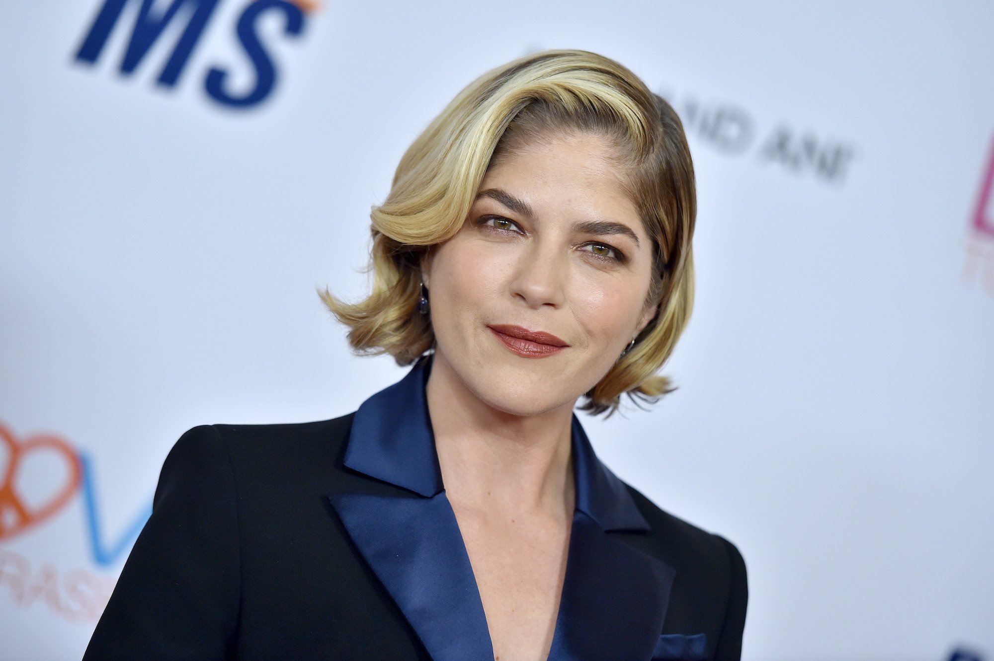 Selma Blair smiling in front of a white background