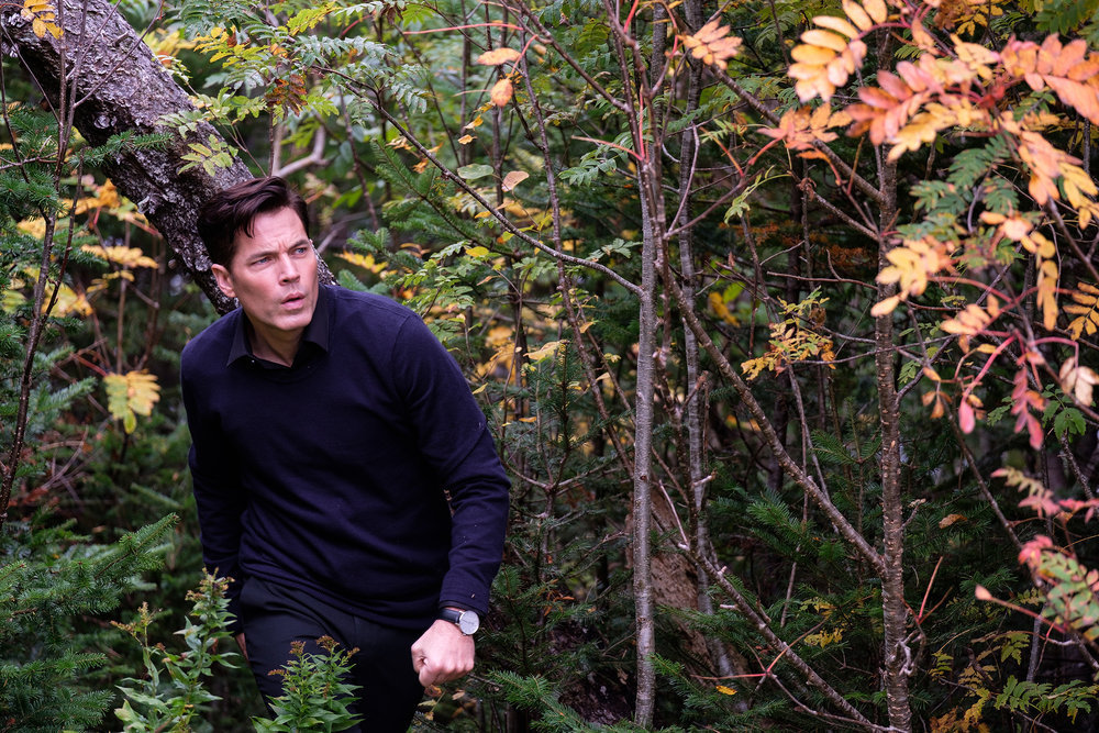 'SurrealEstate' production still with Tim Rozon as Nick Roman in a wooded area