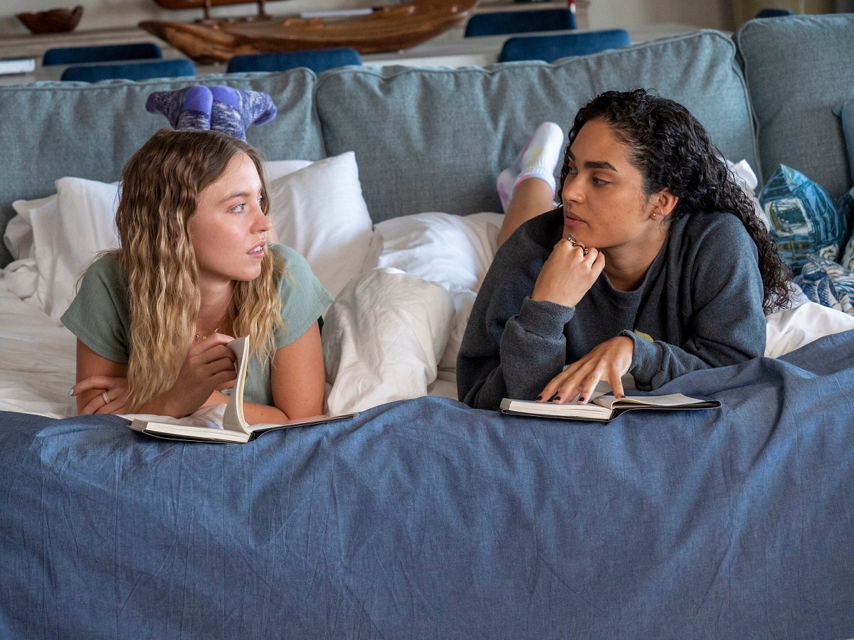 Sydney Sweeney and Brittany O'Grady read books on their hotel bed in 'The White Lotus.'