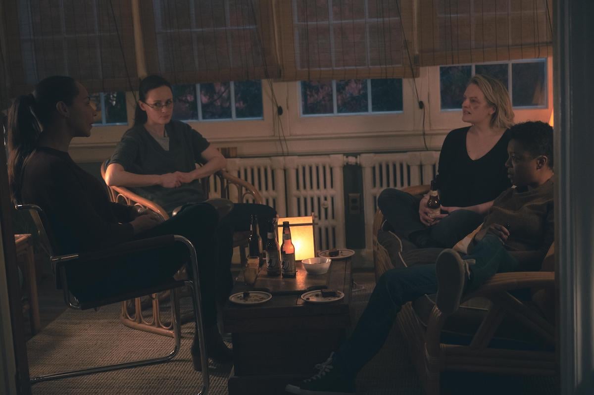 Amanda Brugel, Alexis Bledel, Elisabeth Moss, and Samira Wiley in 'The Handmaid's Tale' Season 4 Episode 7. They sit in a living room holding drinks in their hands. It's night.