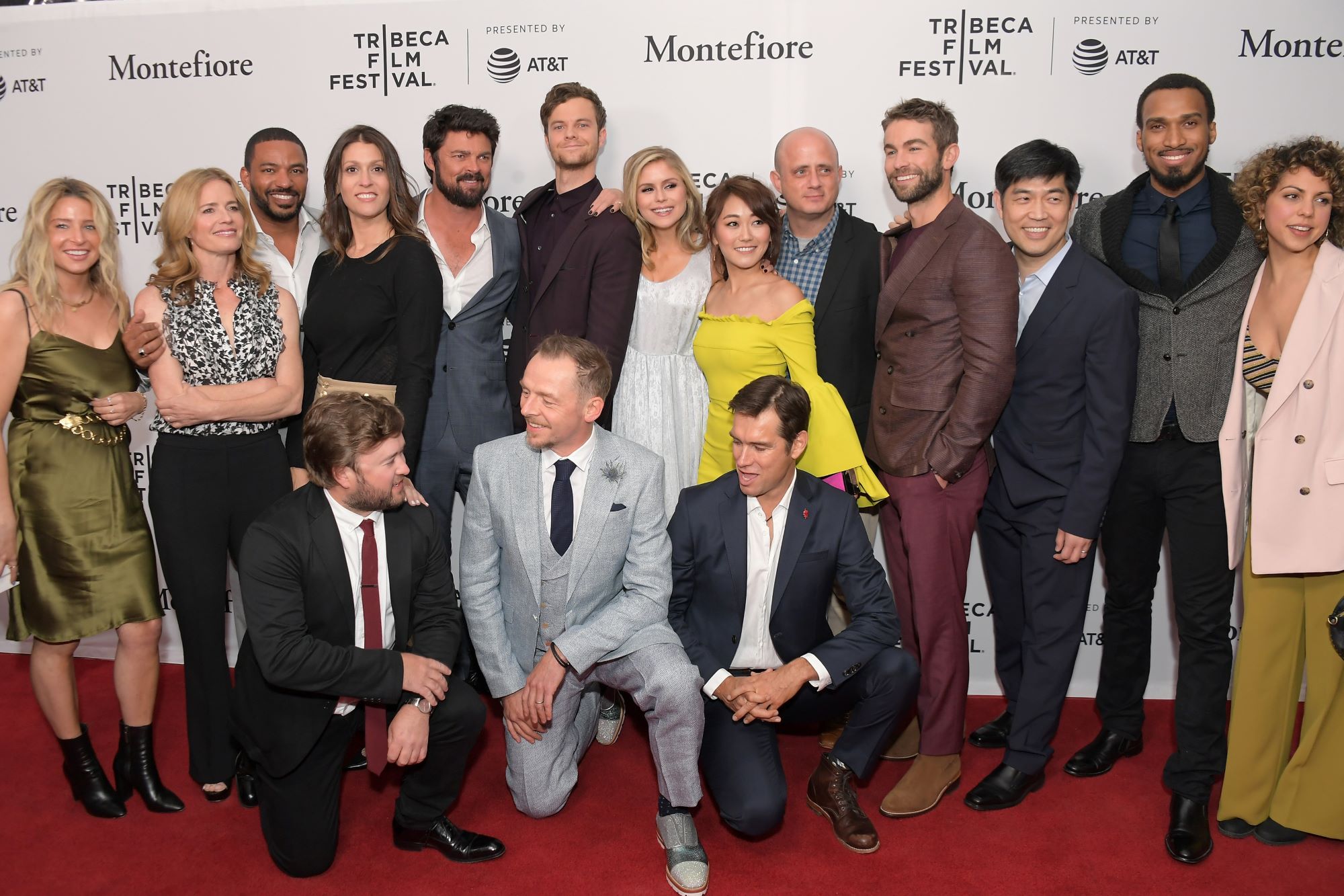 A picture of the cast of 'The Boys' in front of a white background with black writing on the red carpet.