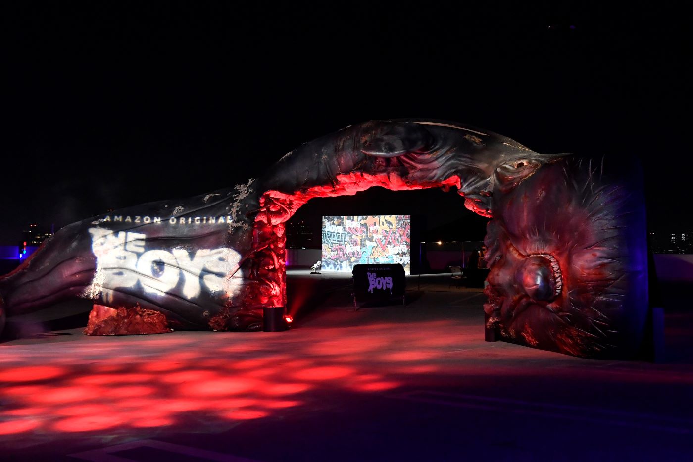 a large structure is lit up with red with 'The Boy's' lit up in white on the side.