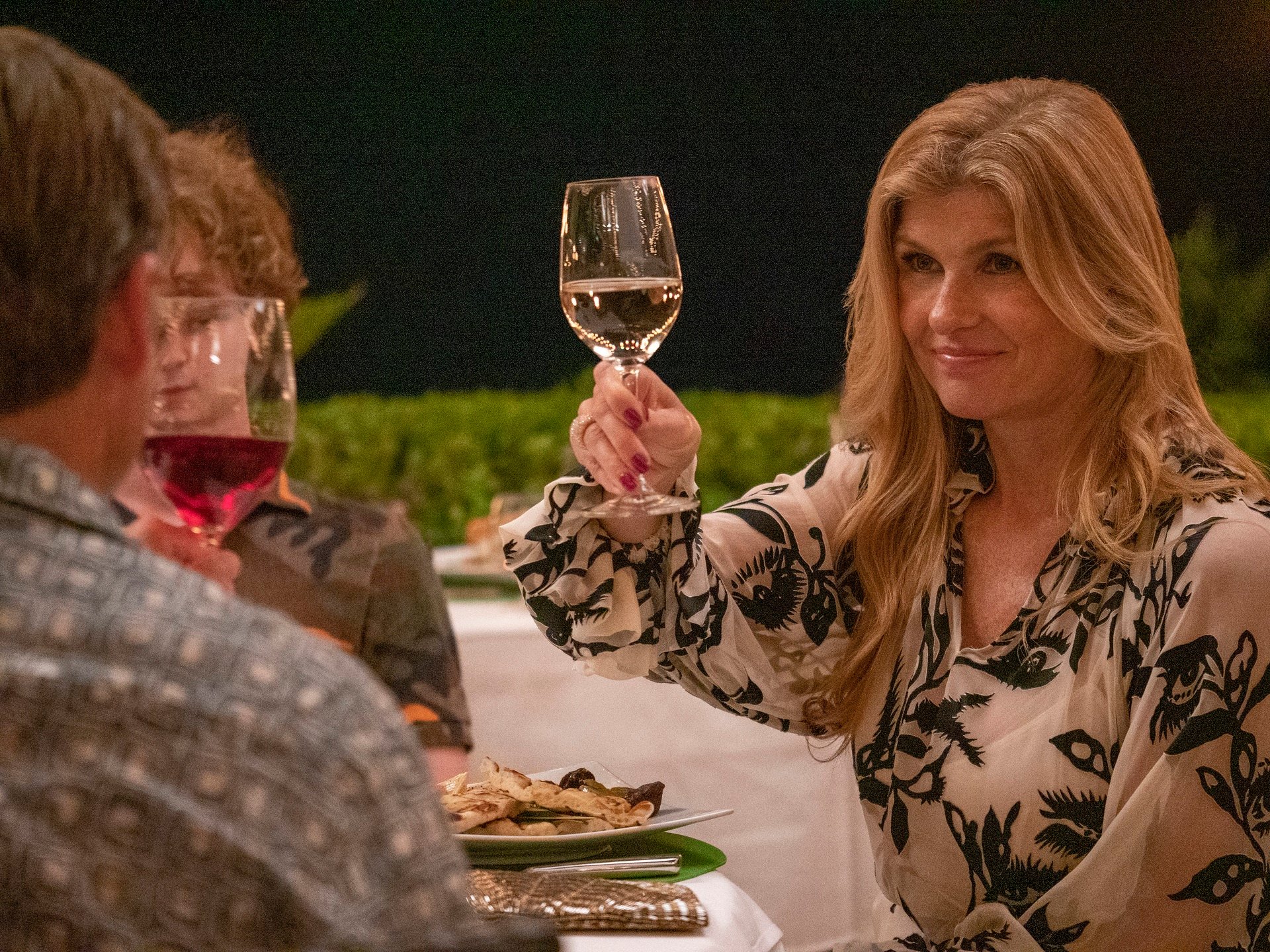 The White Lotus Episode 2 Connie Britton as Nicole Mossbacher raising a glass.