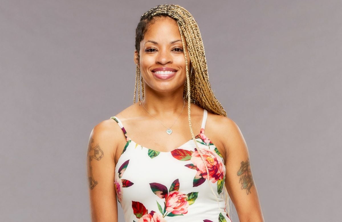 Tiffany Mitchell smiles and wears a white floral dress.