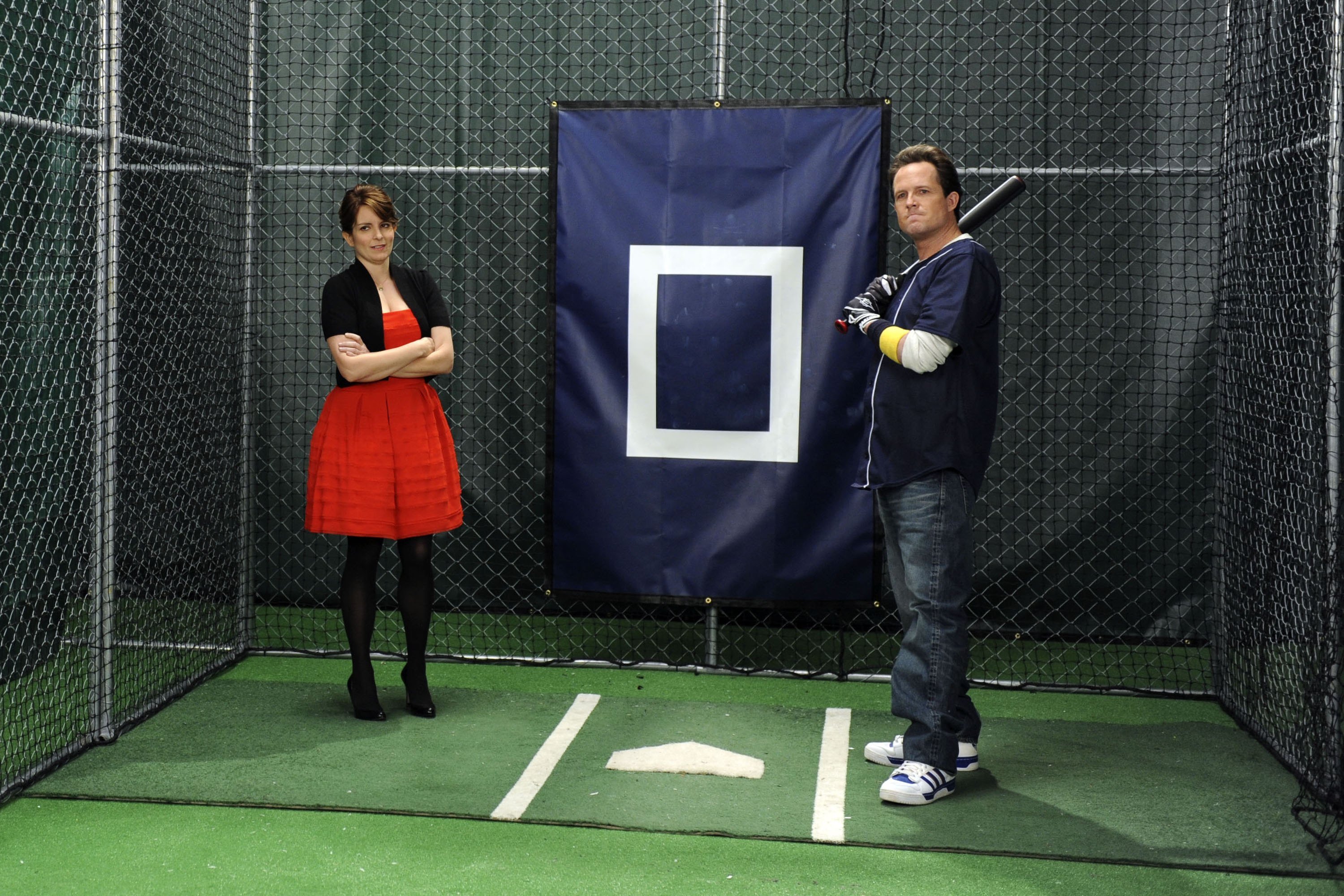 Tina Fey and Dean Winters in a batting cage on '30 Rock'