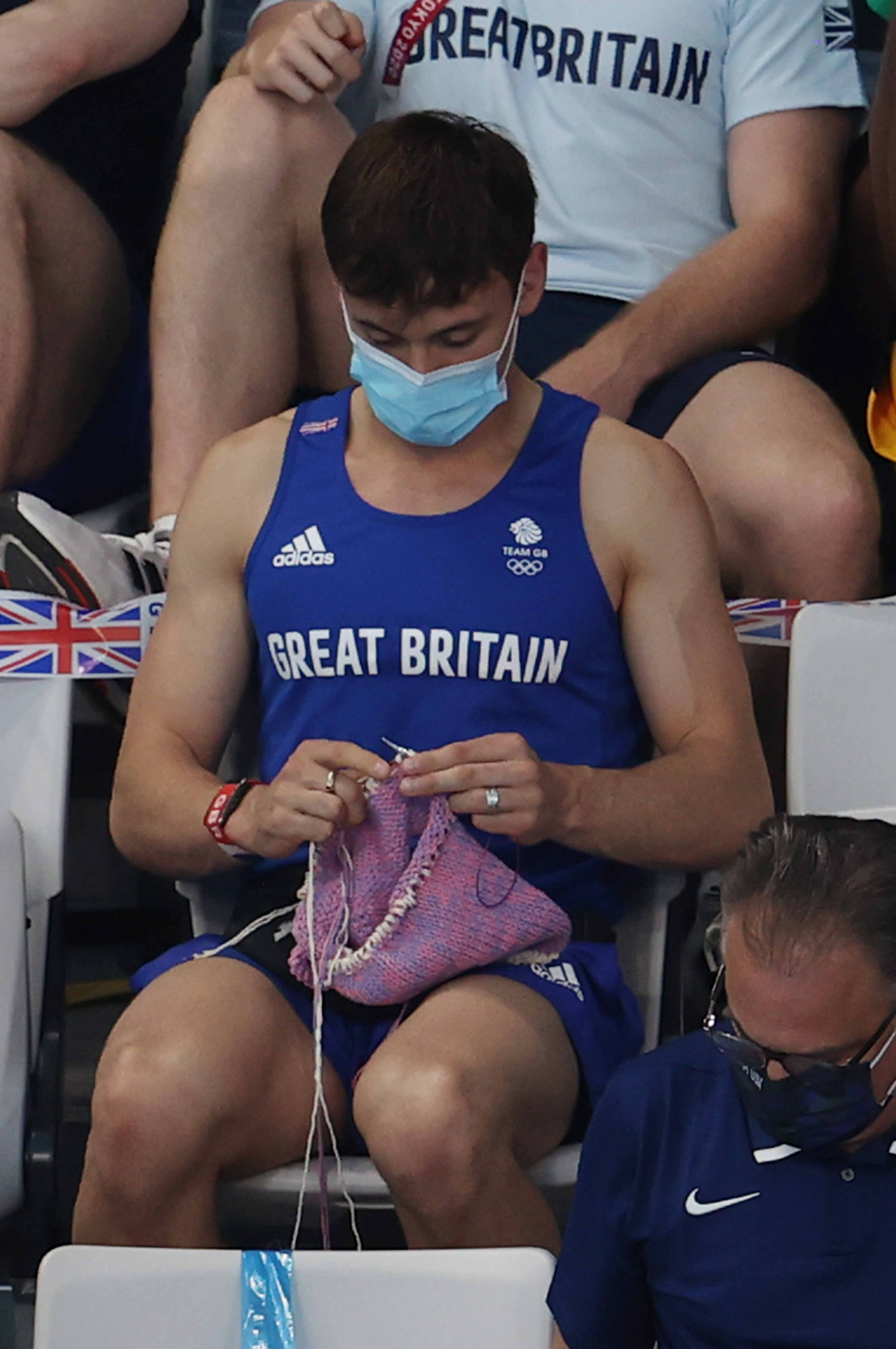 Tom Daley of Great Britain knitting in the stands during women's Olympics springboard final