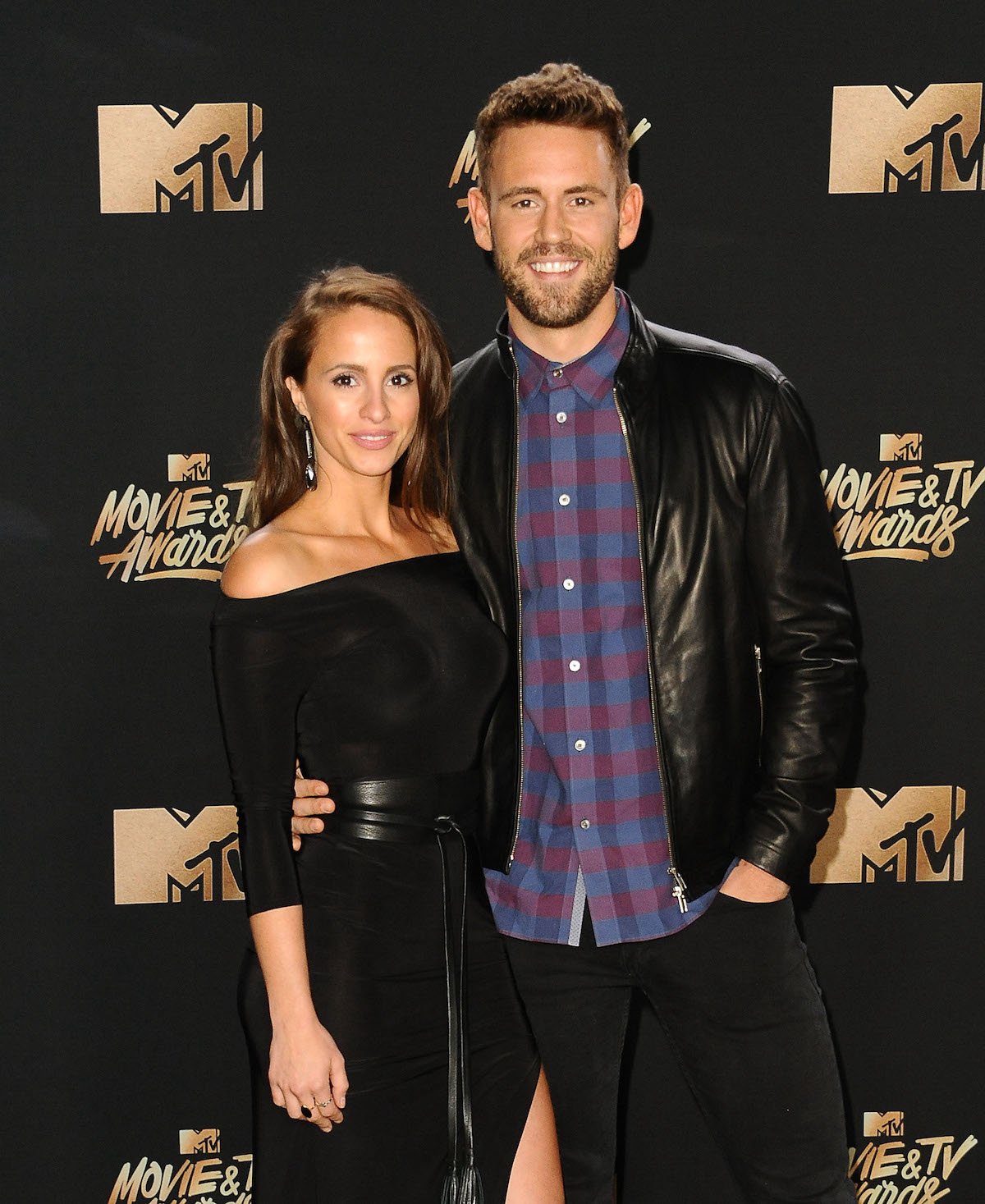 Vanessa Grimaldi and Nick Viall in matching formal black outfits pose for the camera at an event.