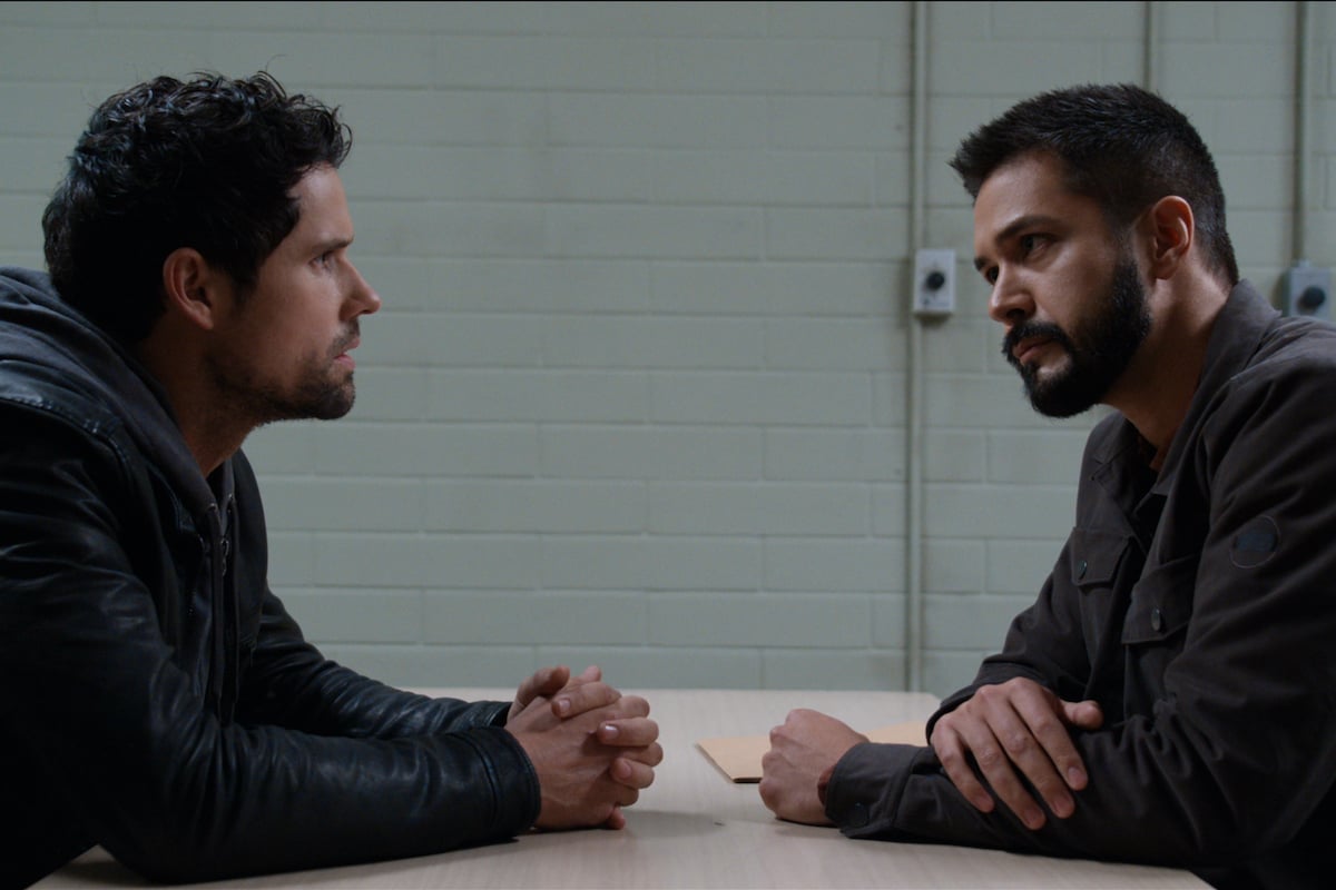 Ben Hollingsworth as Brady sits in the interrogation room with Marco Grazzini as Detective Mike Valenzuela in 'Virgin River'