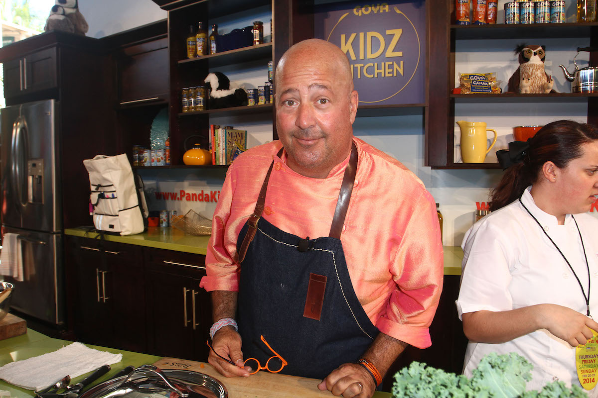 Andrew Zimmern stands in a kitchen