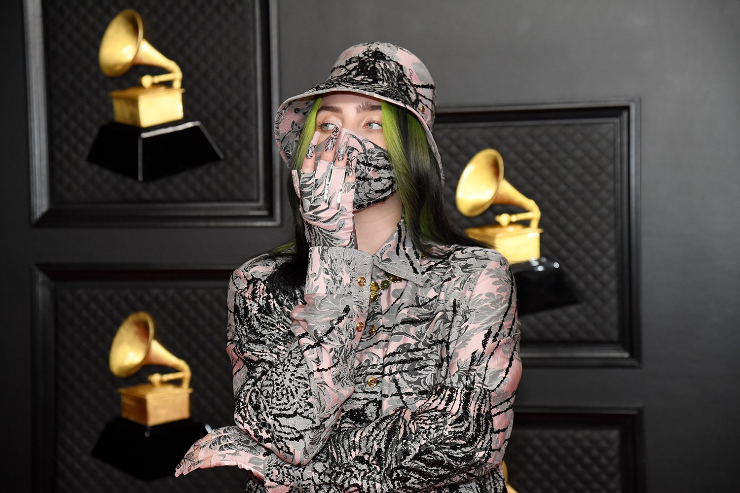 Billie Eilish wears a face mask and covers her mouth with her hand at the 63rd Annual Grammy Awards