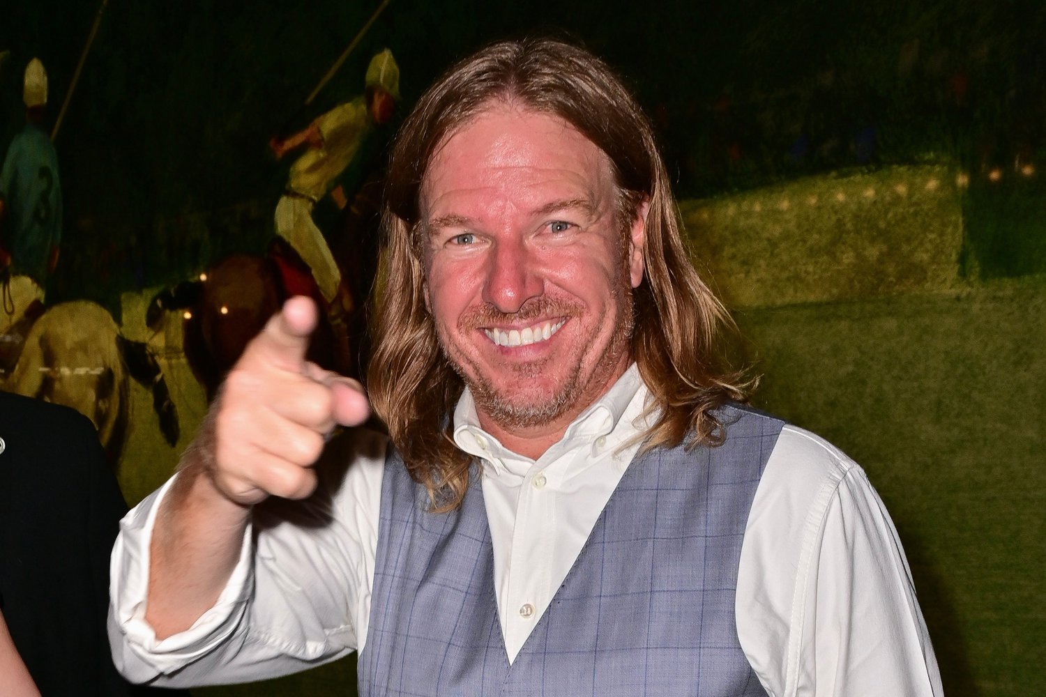 Chip Gaines sporting his long hair, smiling and pointing