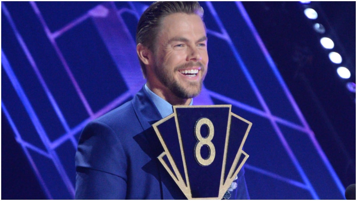 Derek Hough holds a scoring paddle on the DWTS set.