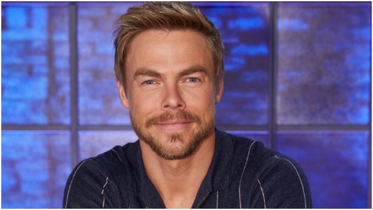 Derek Hough poses for a photograph in a black shirt.