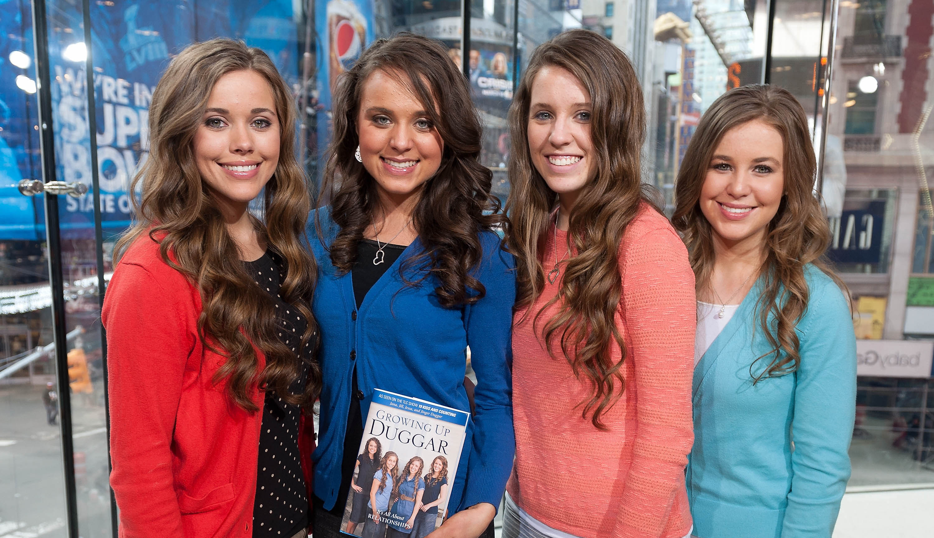 Jessa Duggar, Jinger Duggar, Jill Duggar, and Jana Duggar of the Duggar family standing next to each other at 'Extra' studios