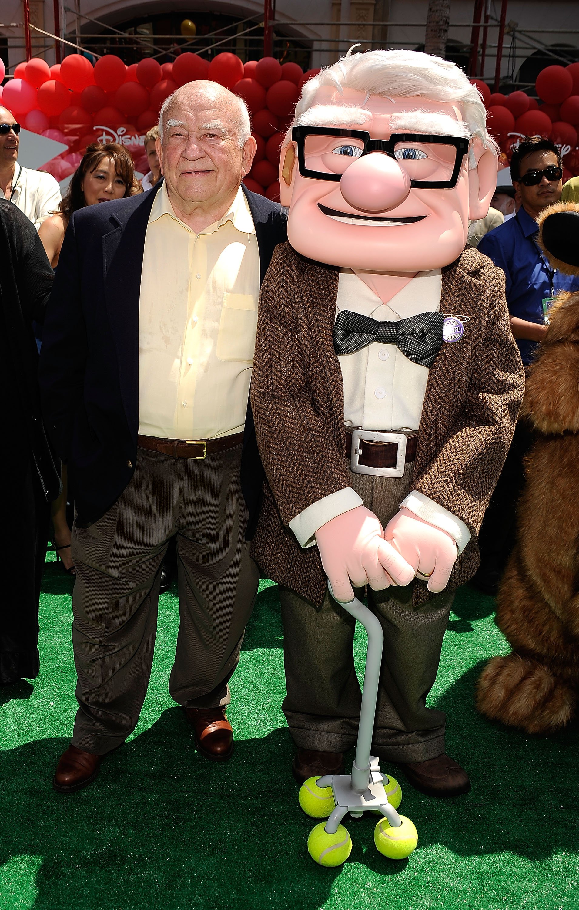 Ed Asner standing next to the character he voiced in the movie 'Up' during the premiere in 2009