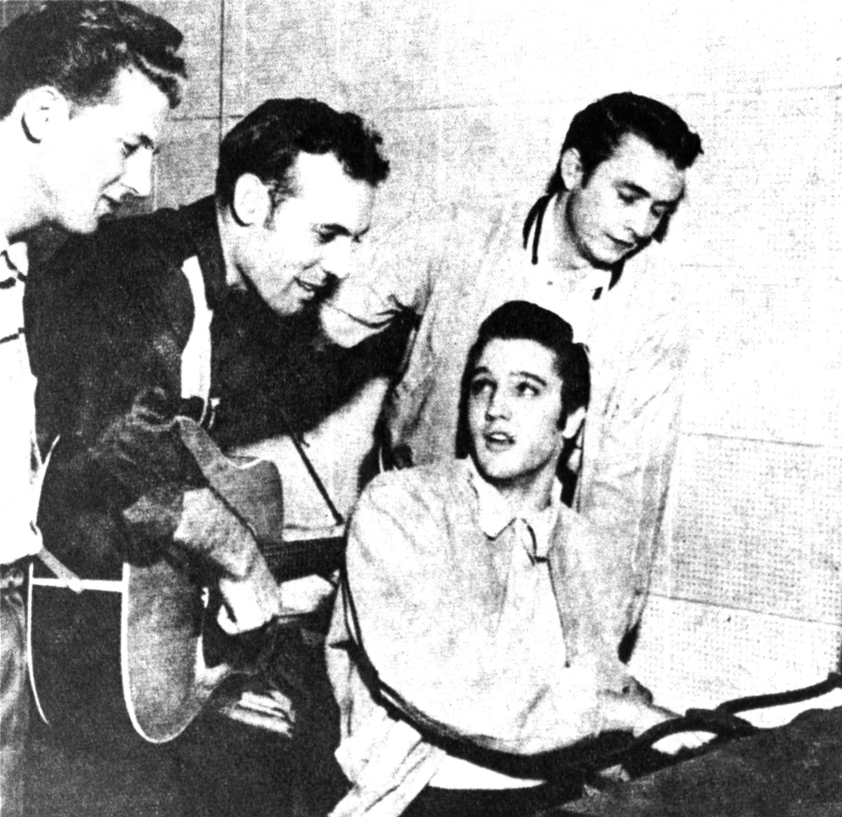 Jerry Lee Lewis, Carl Perkins, Elvis Presley, and Johnny Cash playing songs near a piano