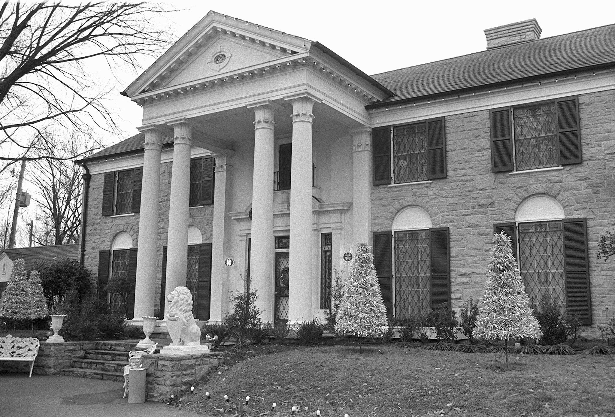 Elvis Presley's Graceland with Christmas trees in the front