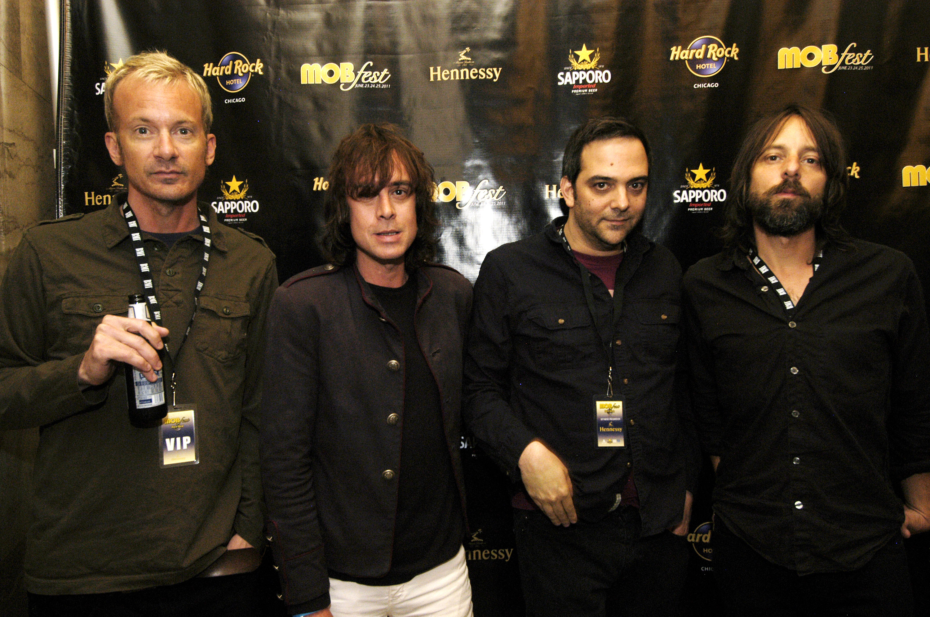 Chris Collingwood, Jody Porter, Adam Schlesinger, and Brian Young of Fountains of Wayne in front of a black backdrop