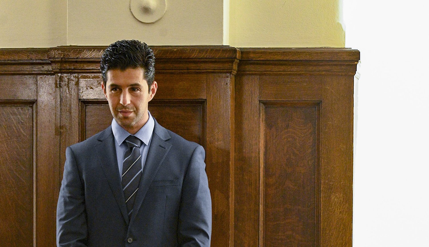 Josh Peck wears a suit in a courtroom in Turner & Hooch