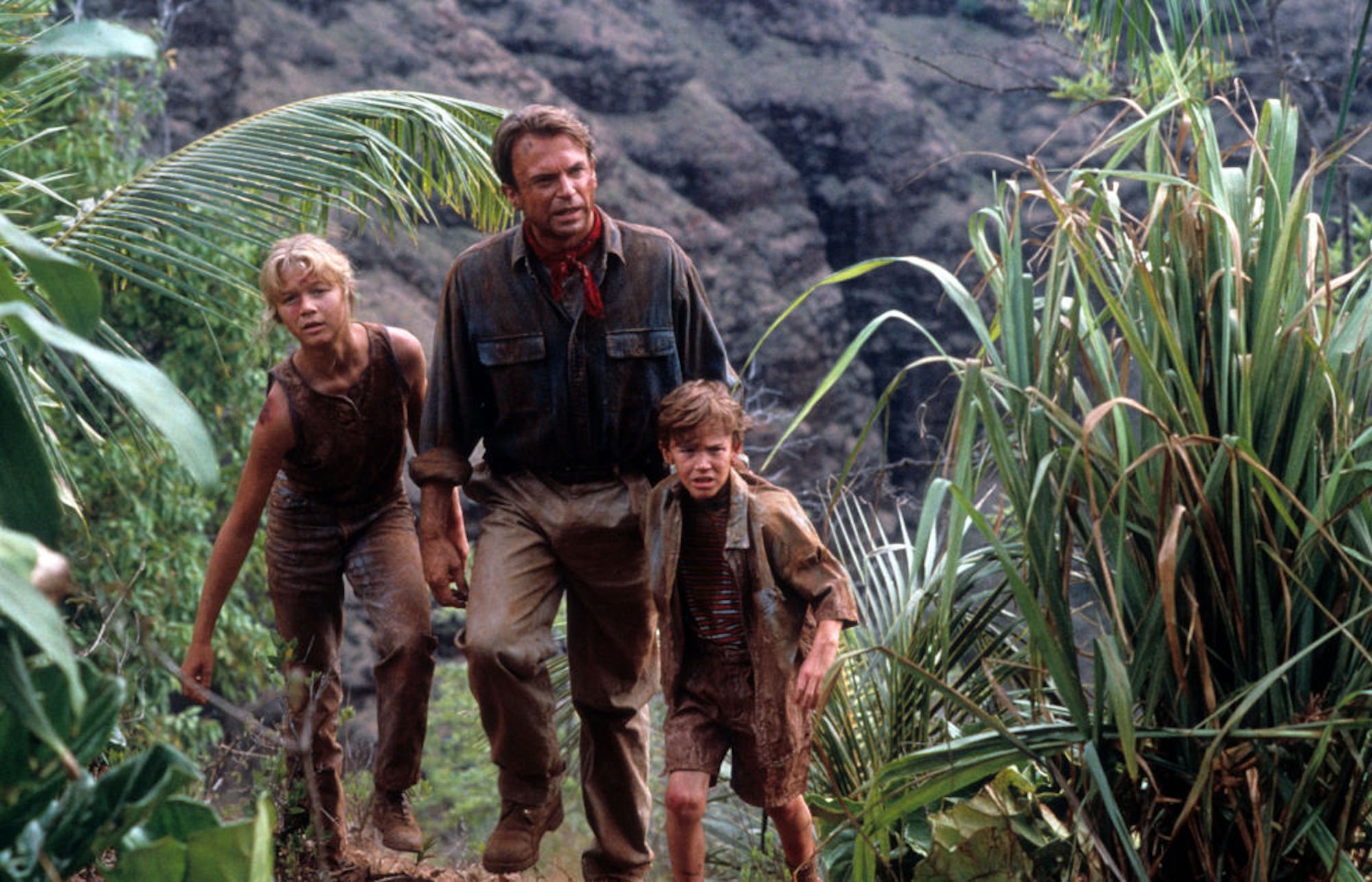 Ariana Richards walks with Sam Neill and Joseph Mazzello in a scene from the film 'Jurassic Park'