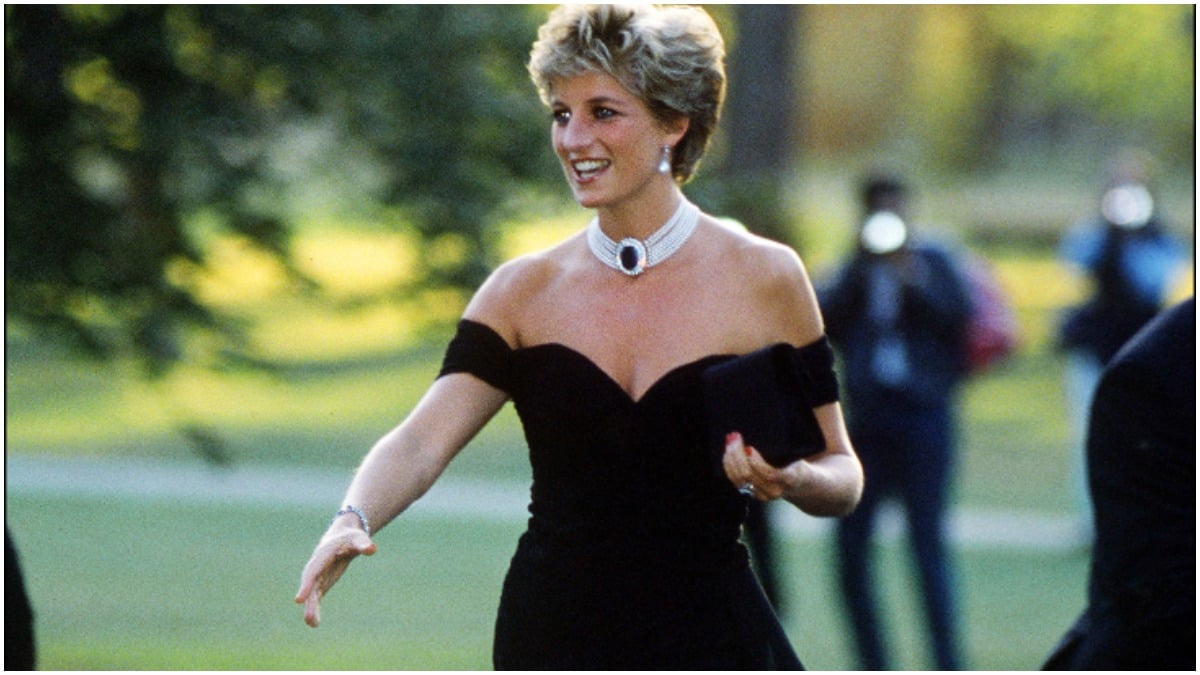 Princess Diana smiles in a black dress as she puts our hand