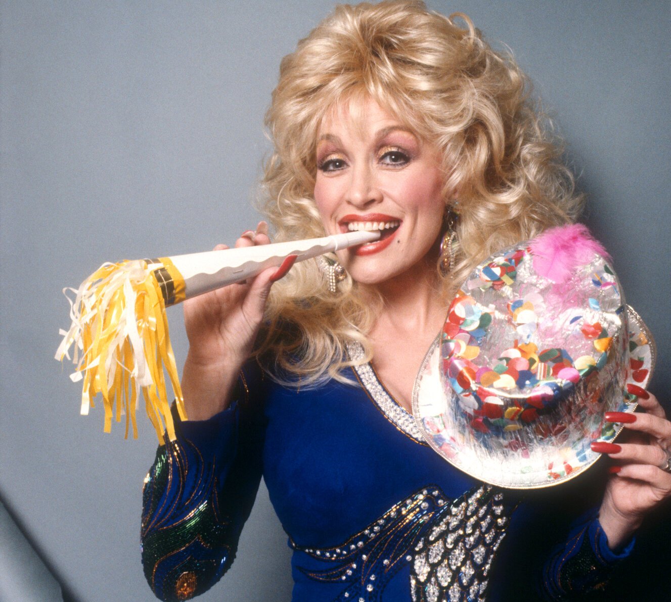 Dolly Parton with a party hat and noise maker in the 1990s.